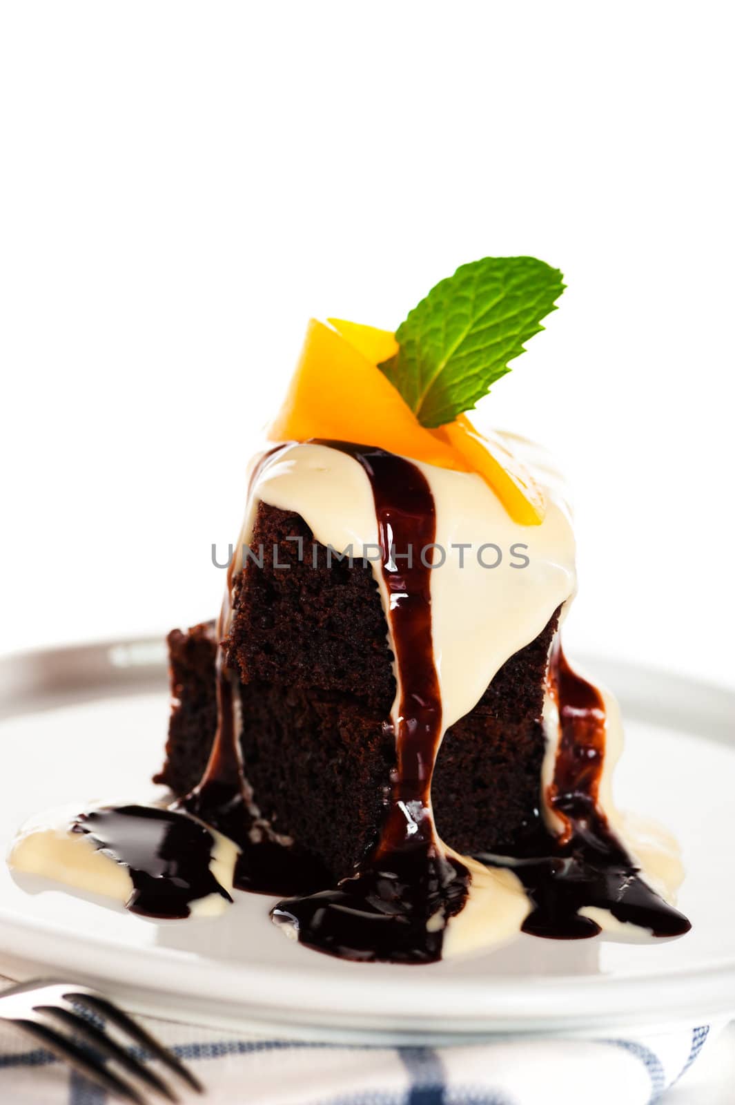 A plate with 2 pieces brownies white and brown chocolate and mango on white background as a studio shot