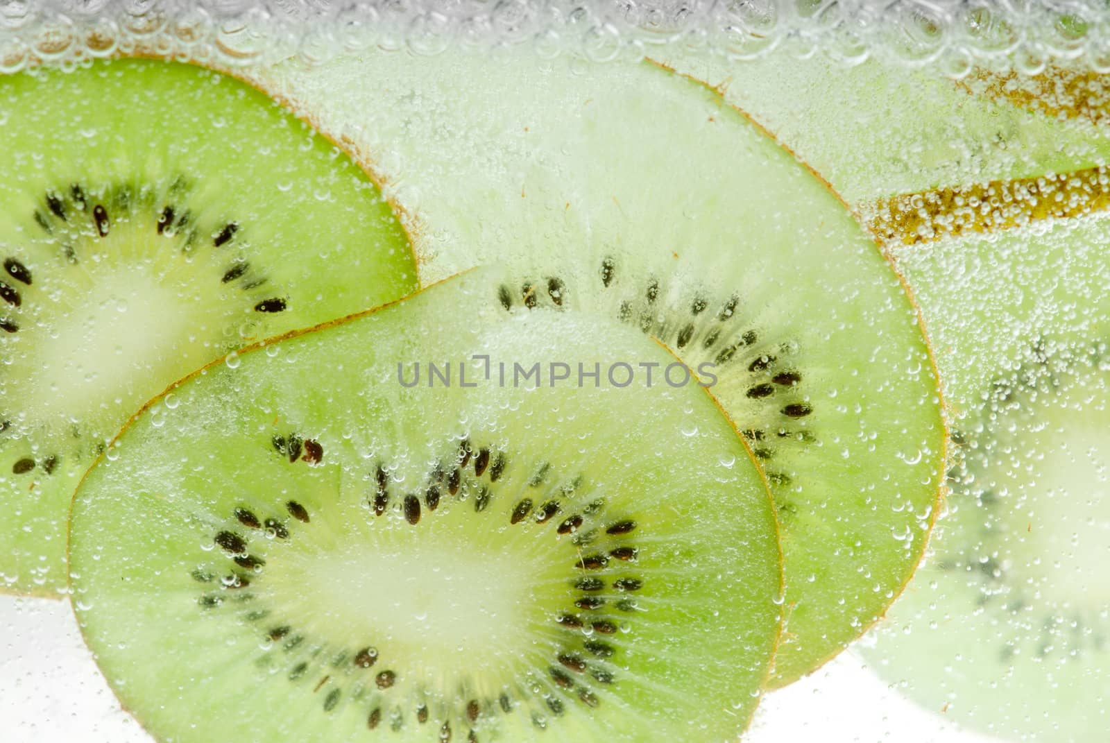 Kiwi macro backlit thin slices in mineral water