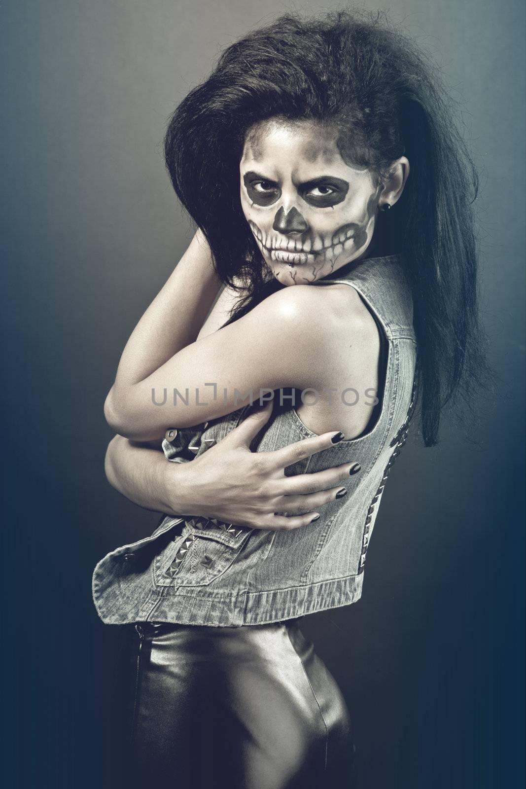 Young woman in day of the dead mask skull. Halloween face art by bloodua
