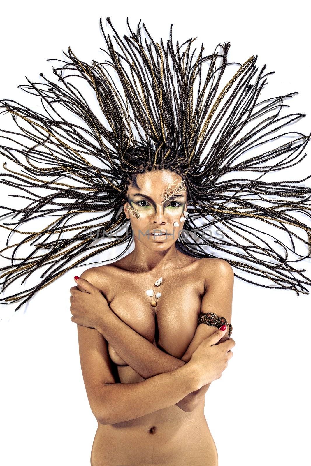 Portrait of a beautiful naked young african american woman with dreadlocks hair lying on a white background