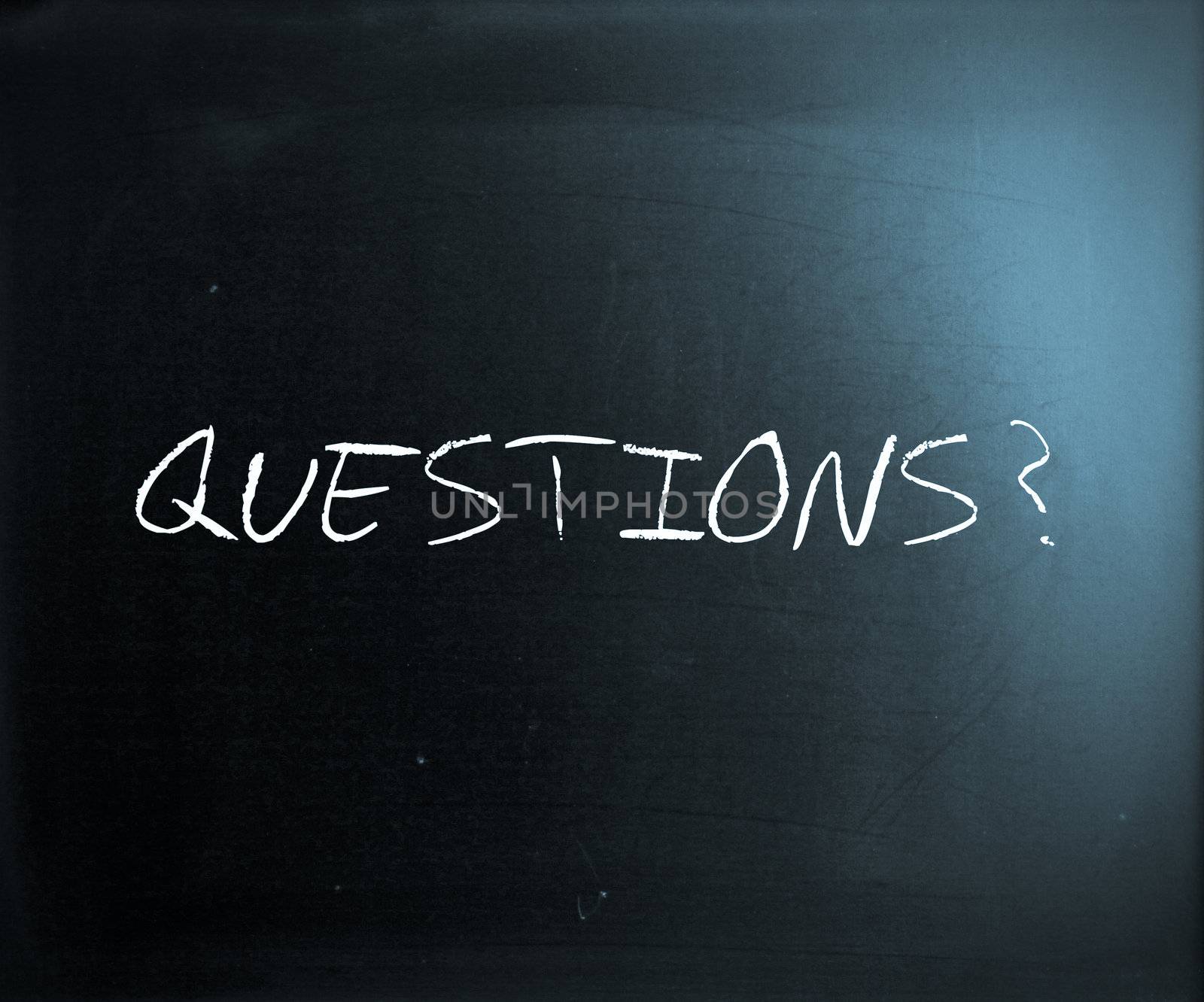 "Questions?" handwritten with white chalk on a blackboard.