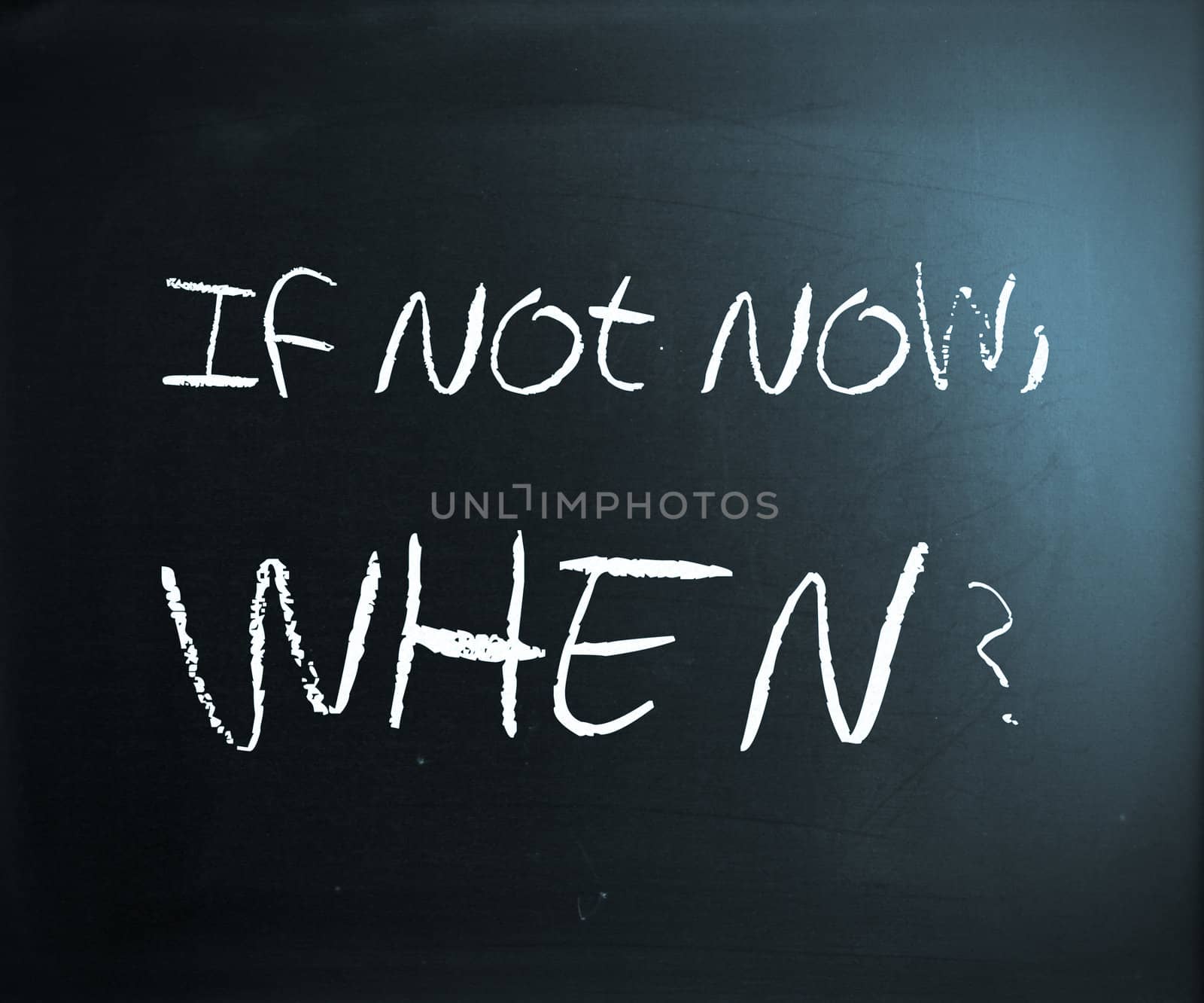 "If not now, when?" handwritten with white chalk on a blackboard.