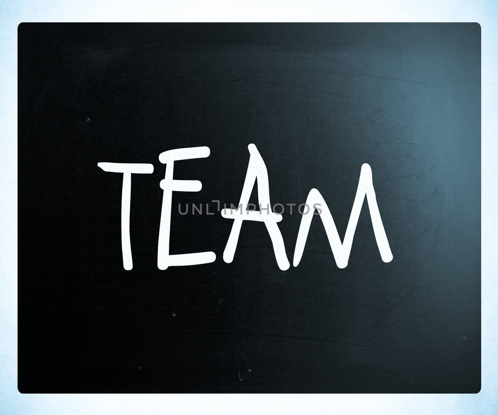 The word "TEAM" handwritten with white chalk on a blackboard