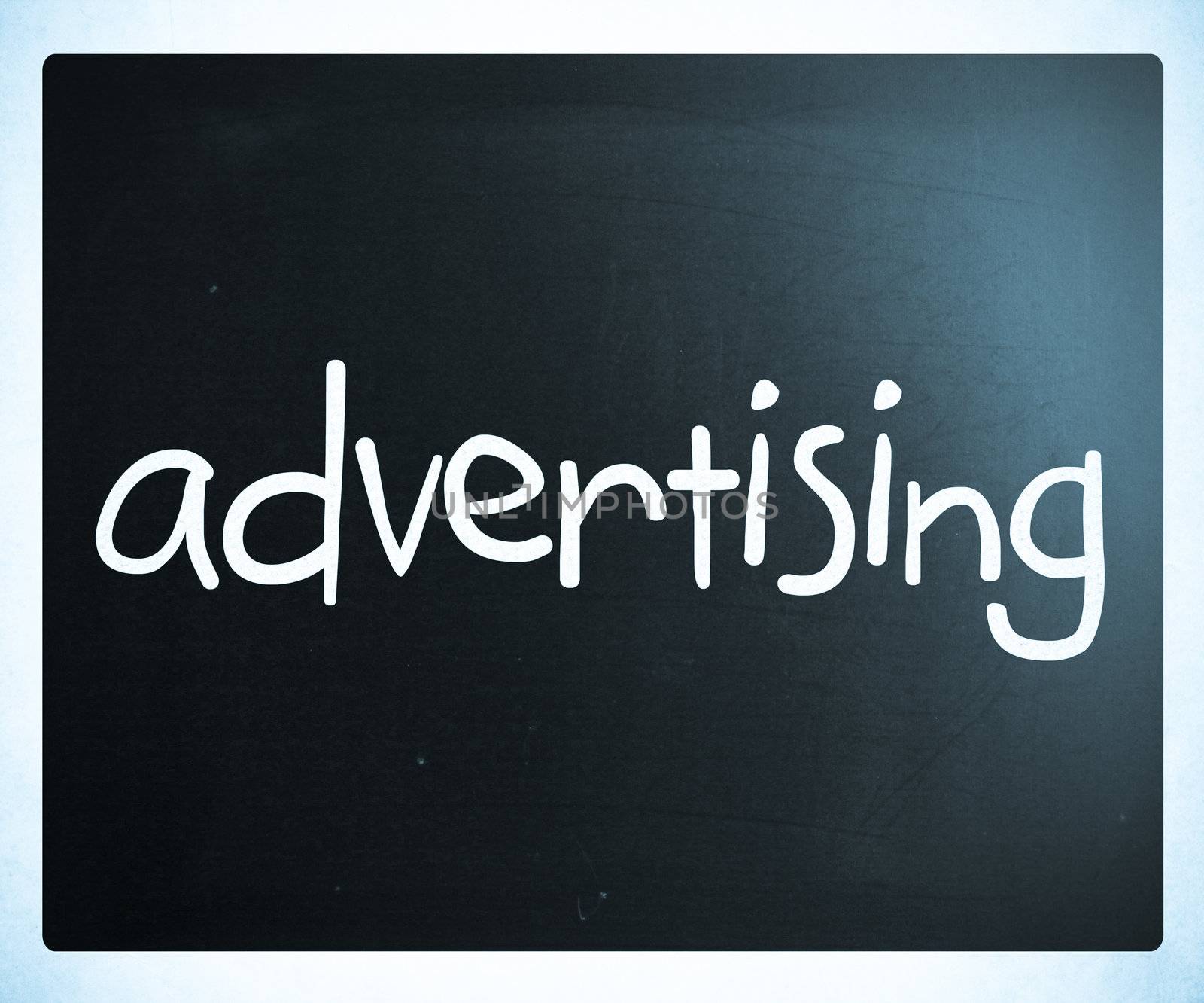 The word "advertising" handwritten with white chalk on a blackboard