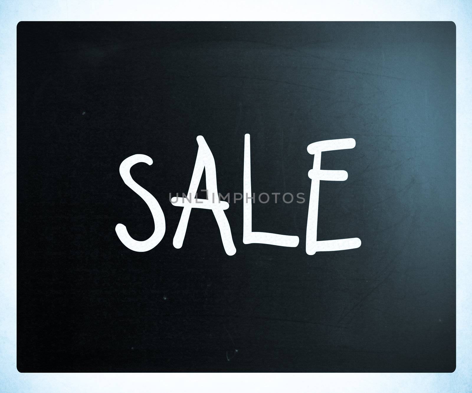 "Sale" handwritten with white chalk on a blackboard
