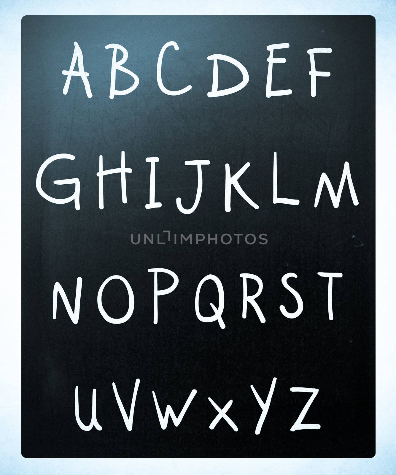 Complete english alphabet handwritten with white chalk on a blackboard