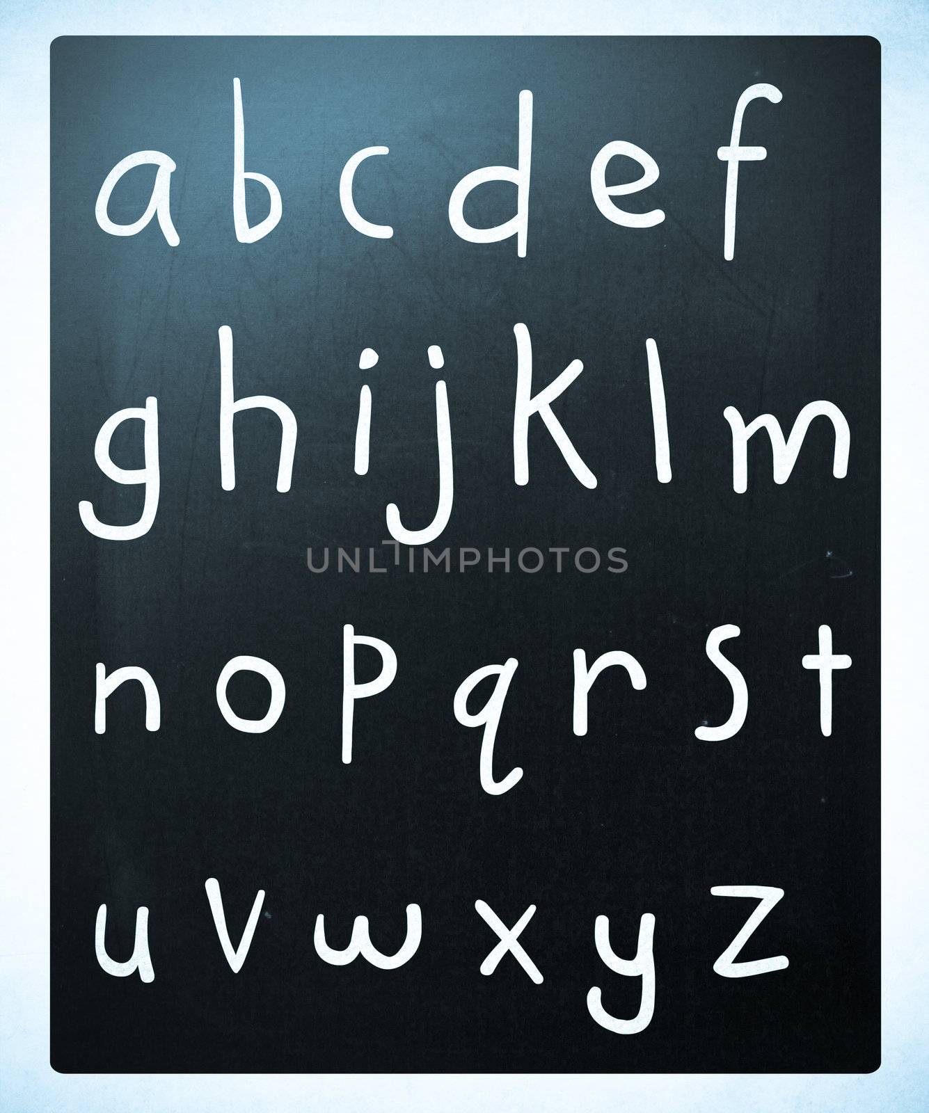 Complete english alphabet handwritten with white chalk on a blackboard