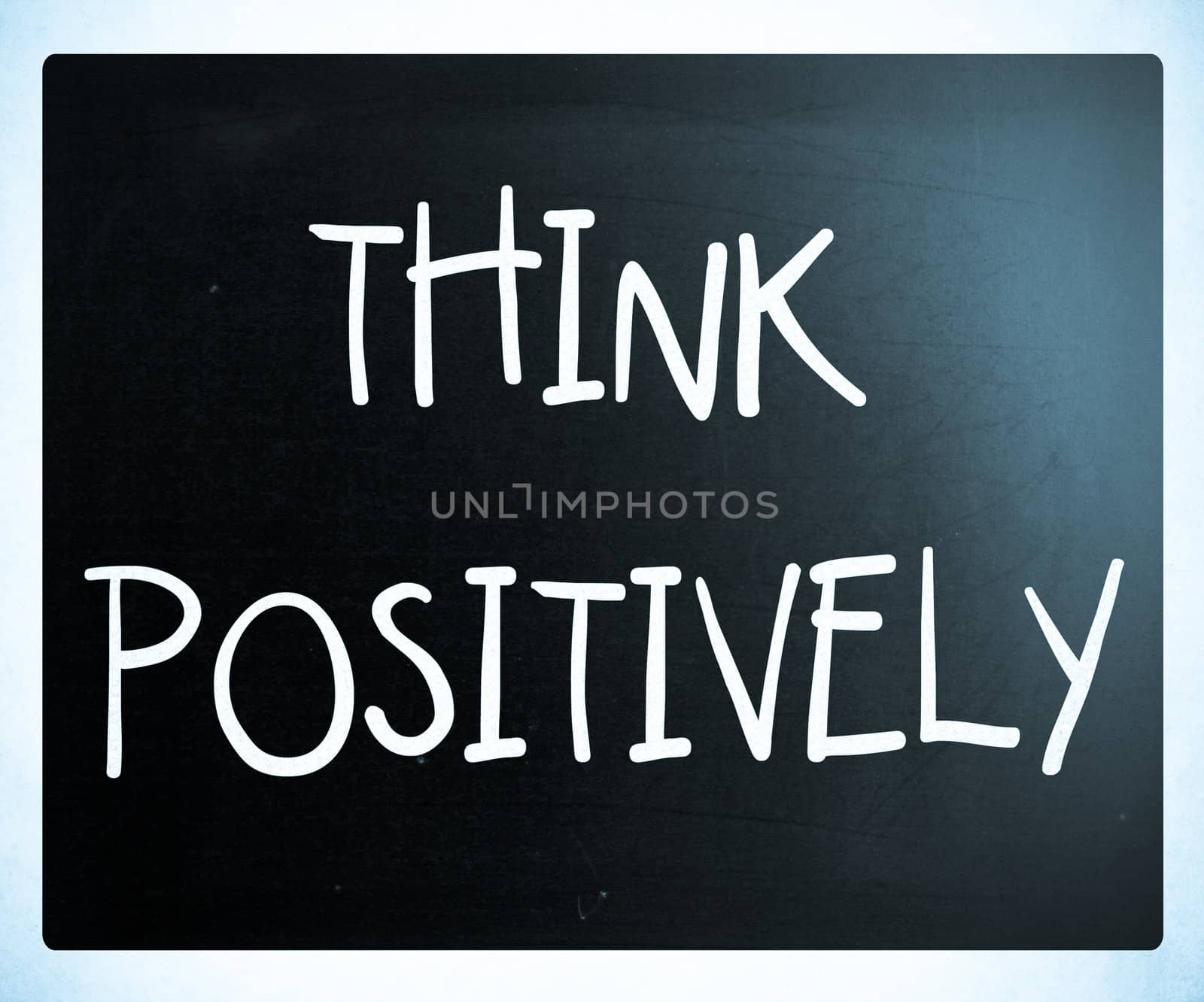 "Think Positively" handwritten with white chalk on a blackboard