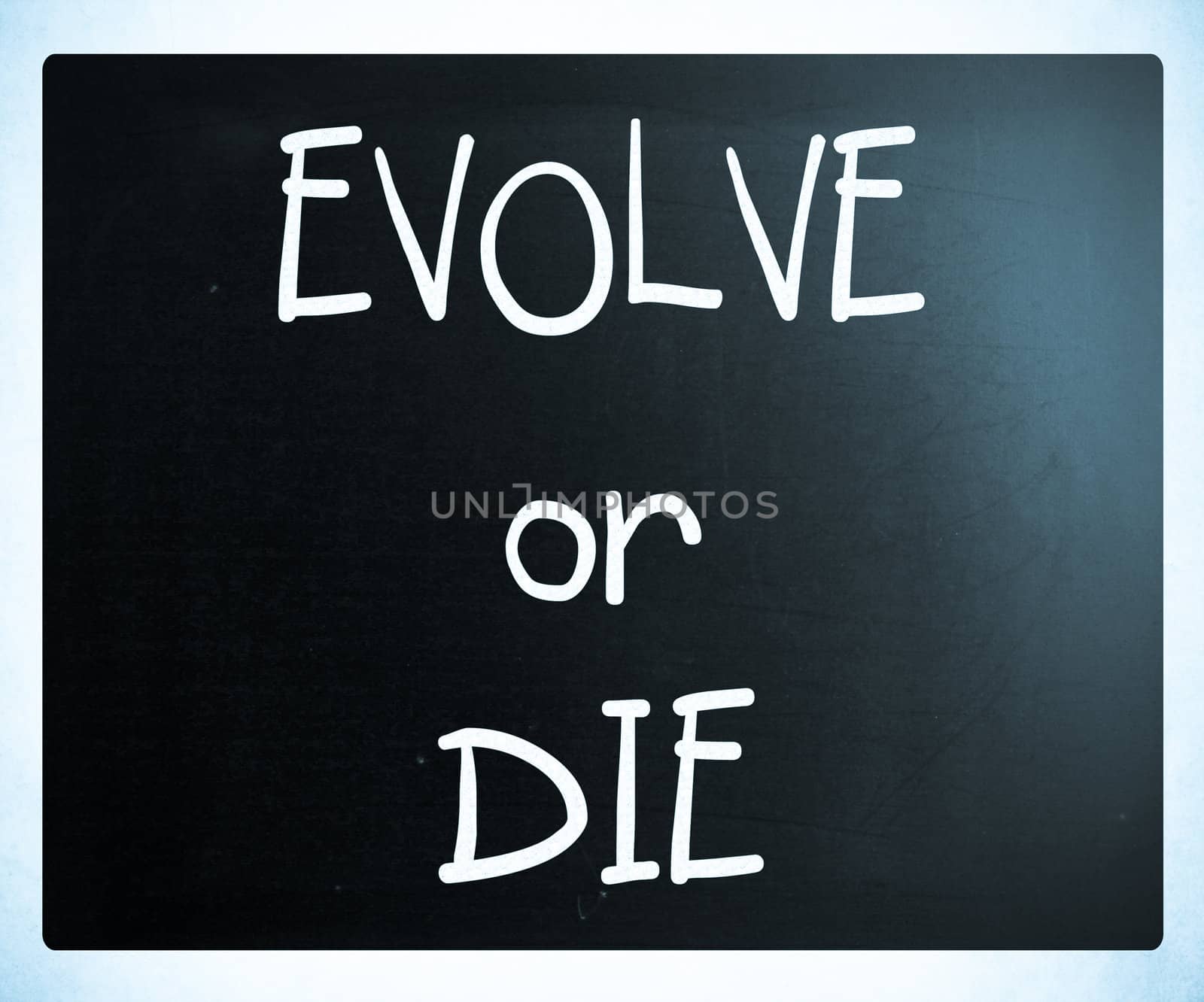 "Evolve or Die" handwritten with white chalk on a blackboard