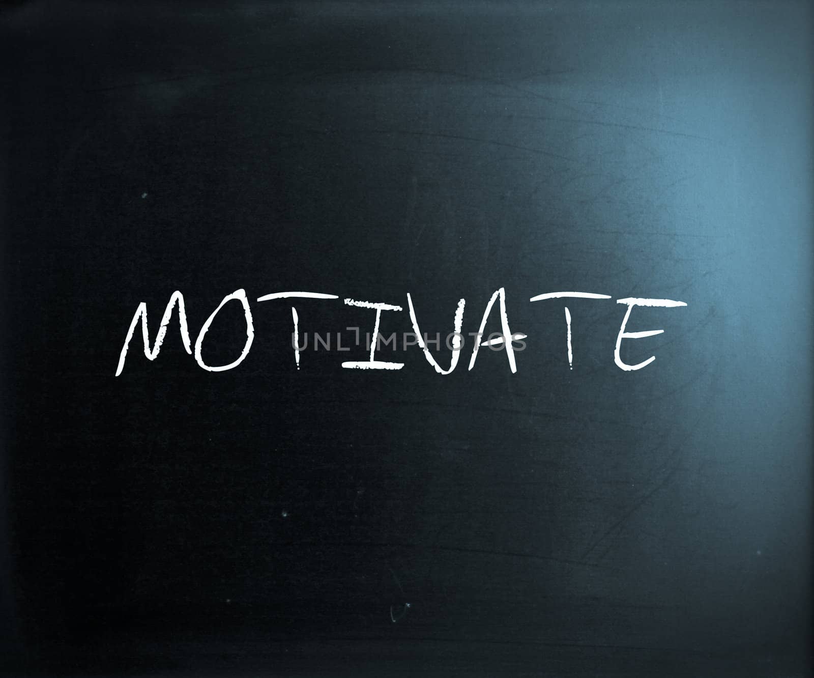 "Motivate" handwritten with white chalk on a blackboard.