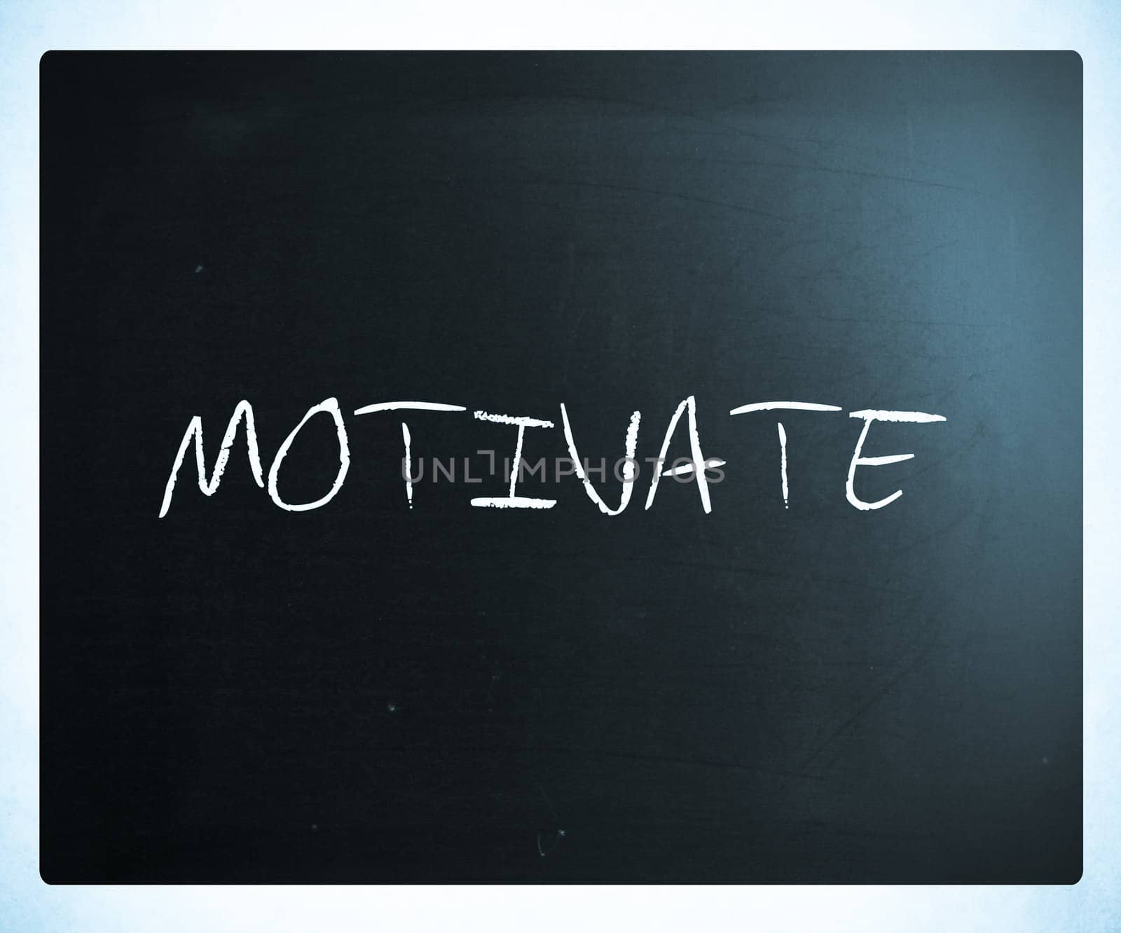 "Motivate" handwritten with white chalk on a blackboard.