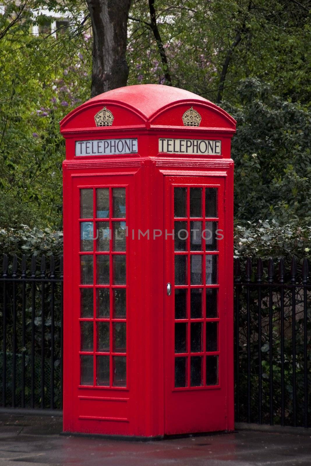 Traditional red telephone box in London by dutourdumonde