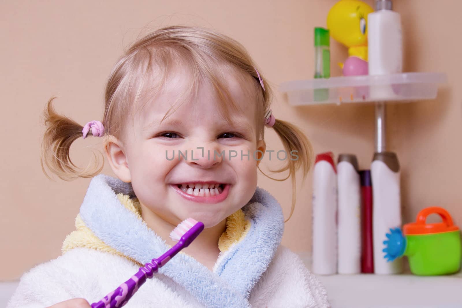 Little girl showing her teeth in bathroom