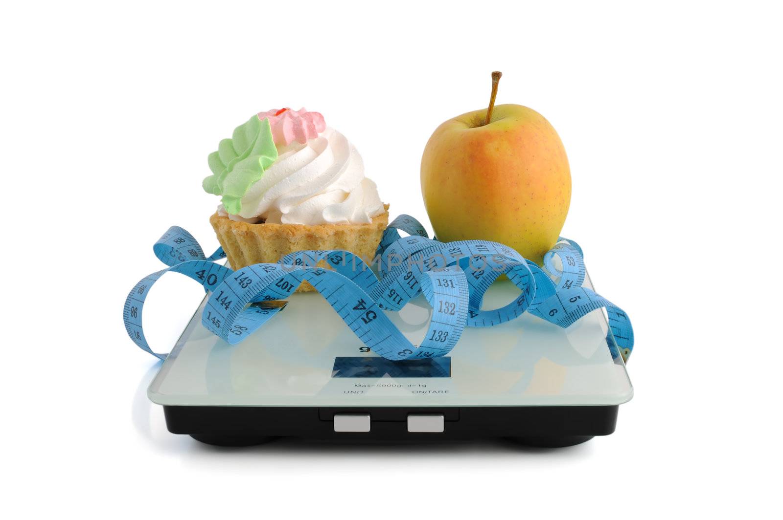 The dilemma of cake or an apple wrapped in the centimeter scale on white background (isolated)