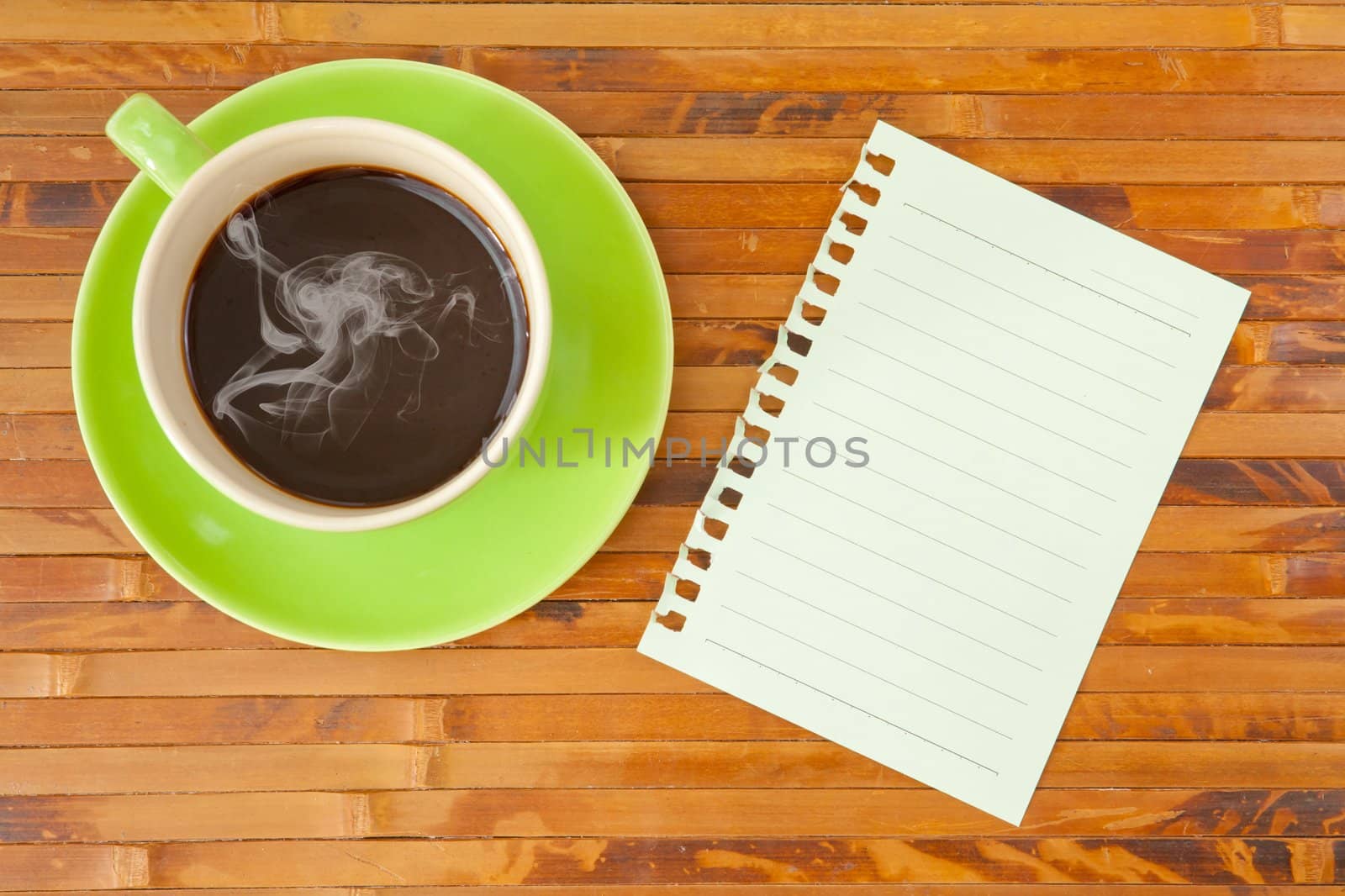 green cup of hot coffee and note paper on wood background