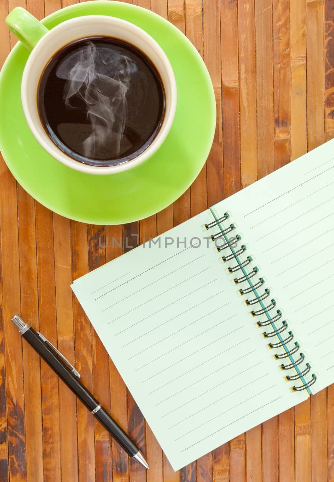 green cup of hot coffee and book on wood background