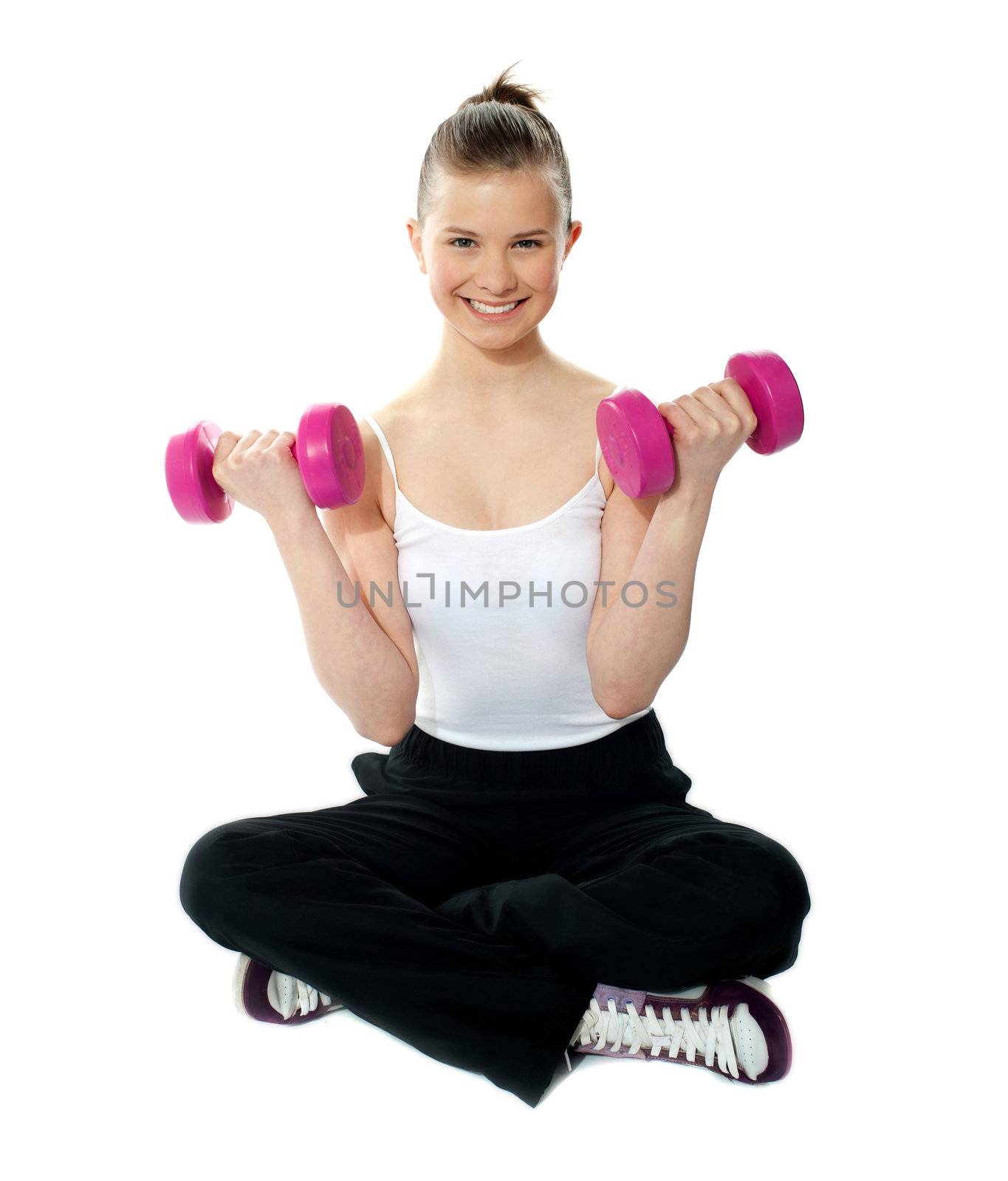 Young girl lifting weights by stockyimages