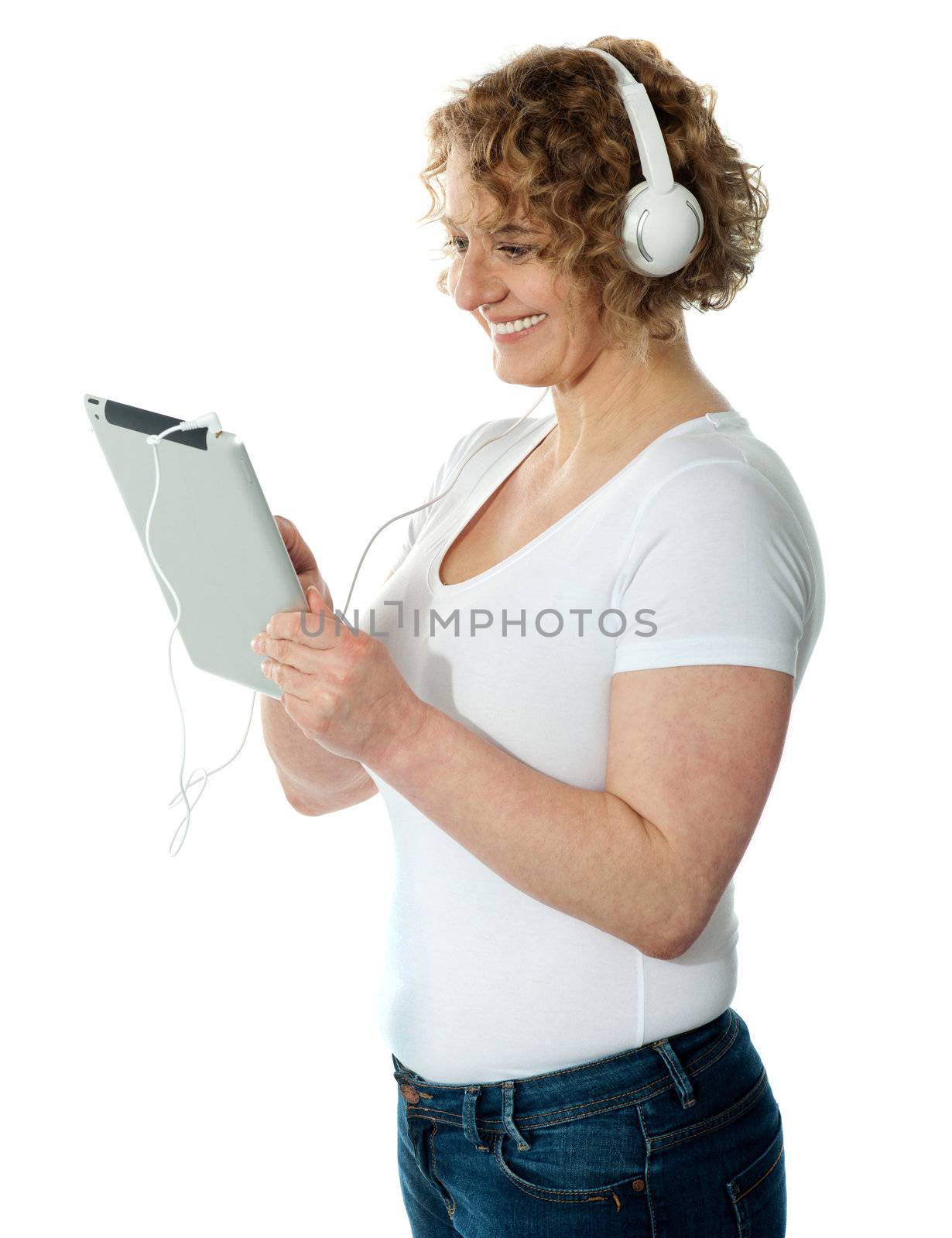 Side view of aged woman listening to music on her i-pad