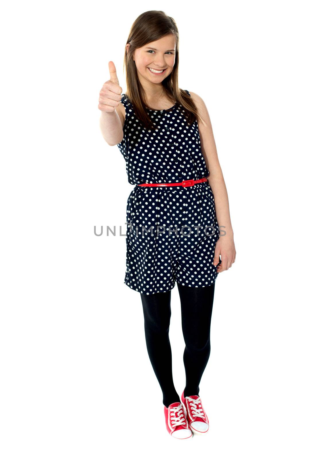 Glamorous teenager gesturing thumbs-up by stockyimages