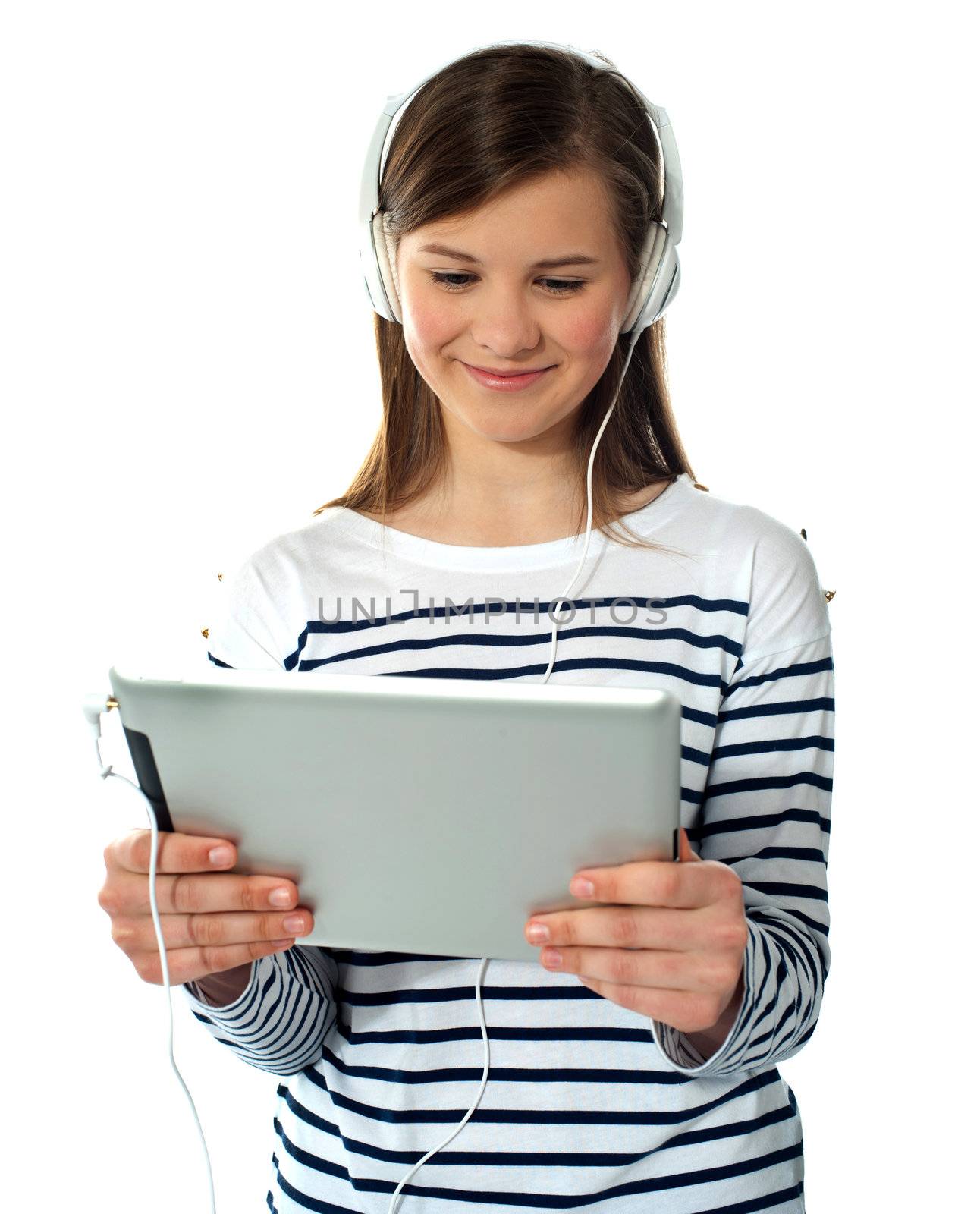 Pretty young girl enjoys listening music by stockyimages