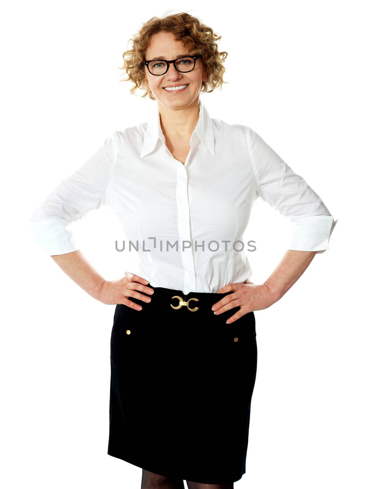 Female executive posing with hands on her waist, smiling at camera