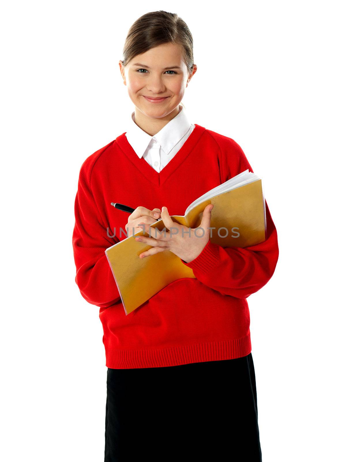 Caucasian student school girl writing on her notebook by stockyimages