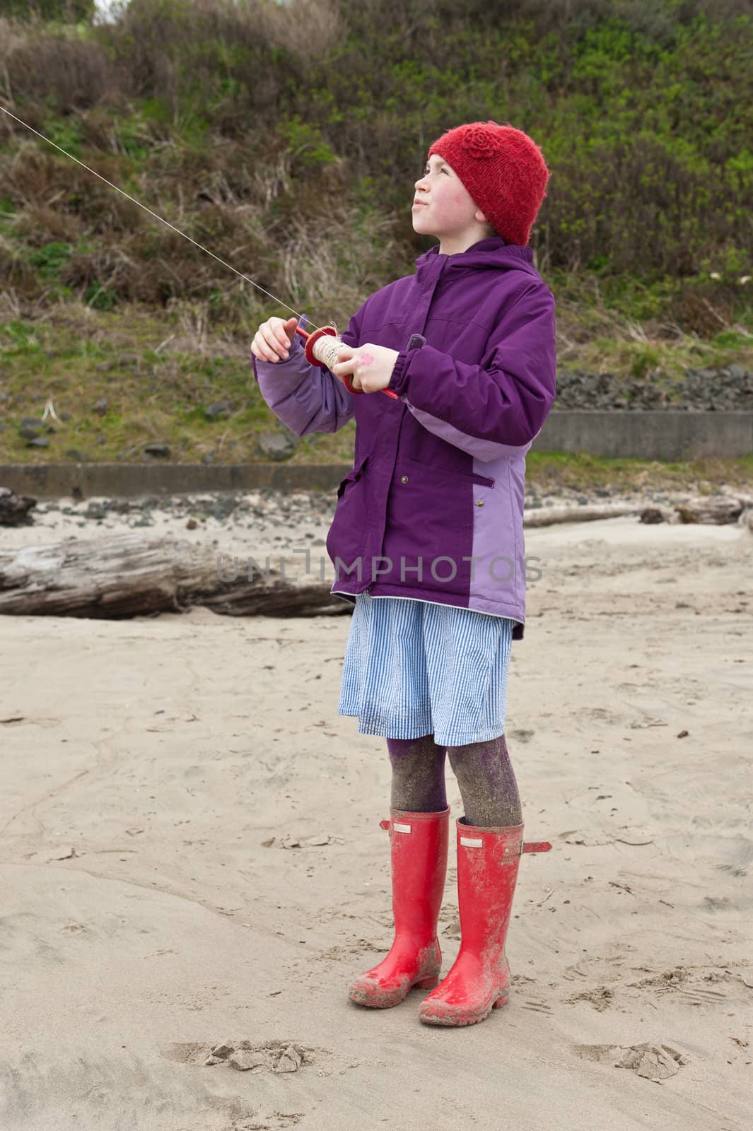 young girl playing kite at beach