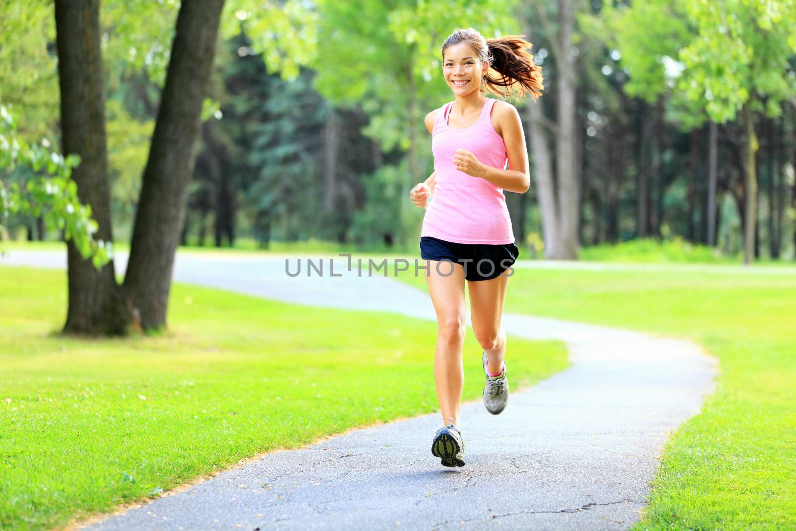Running woman in park in summer training. Asian sport fitness model in sporty running clothes.