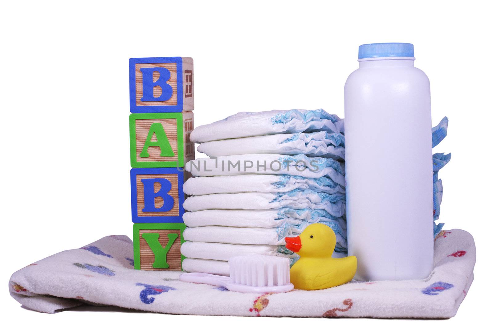 Items for a new baby, diapers, powder, receiving blanket, rubber duck, and brush isolated on white