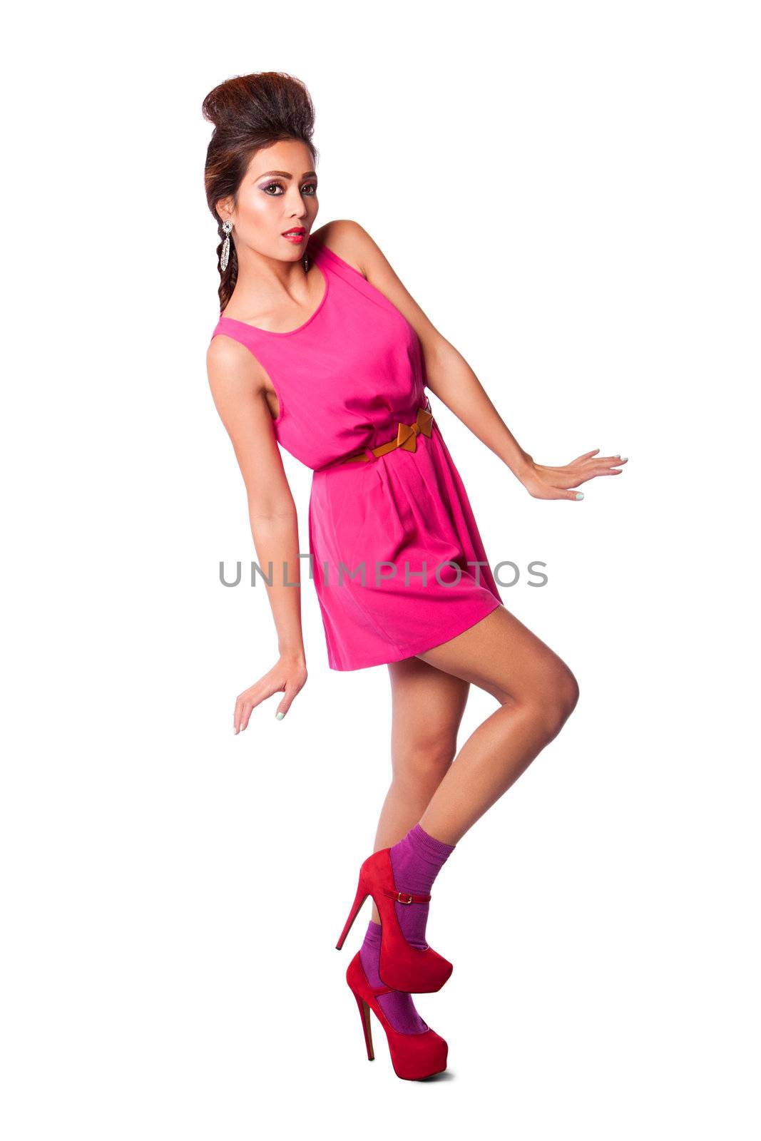 Beautiful attractive fashion woman in pink dress showing curves, long legs, and funky hairstyle.