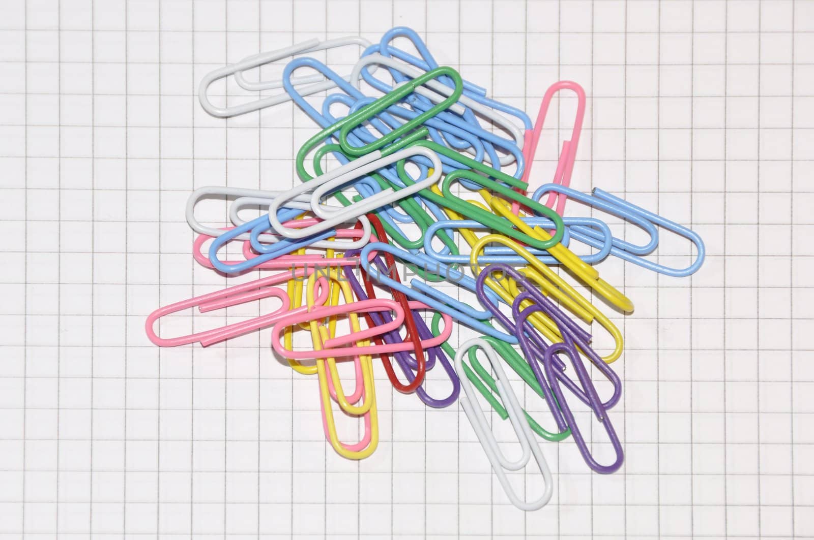 Multi coloured paper clips on a writing-book