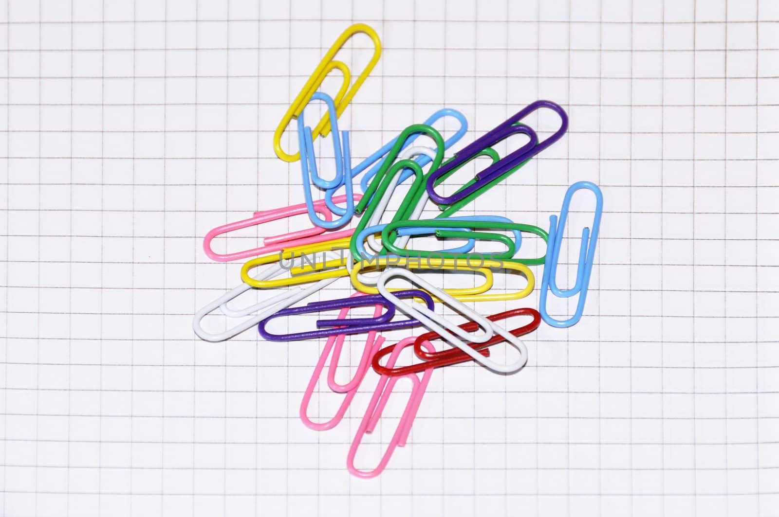 Multi coloured paper clips on a writing-book