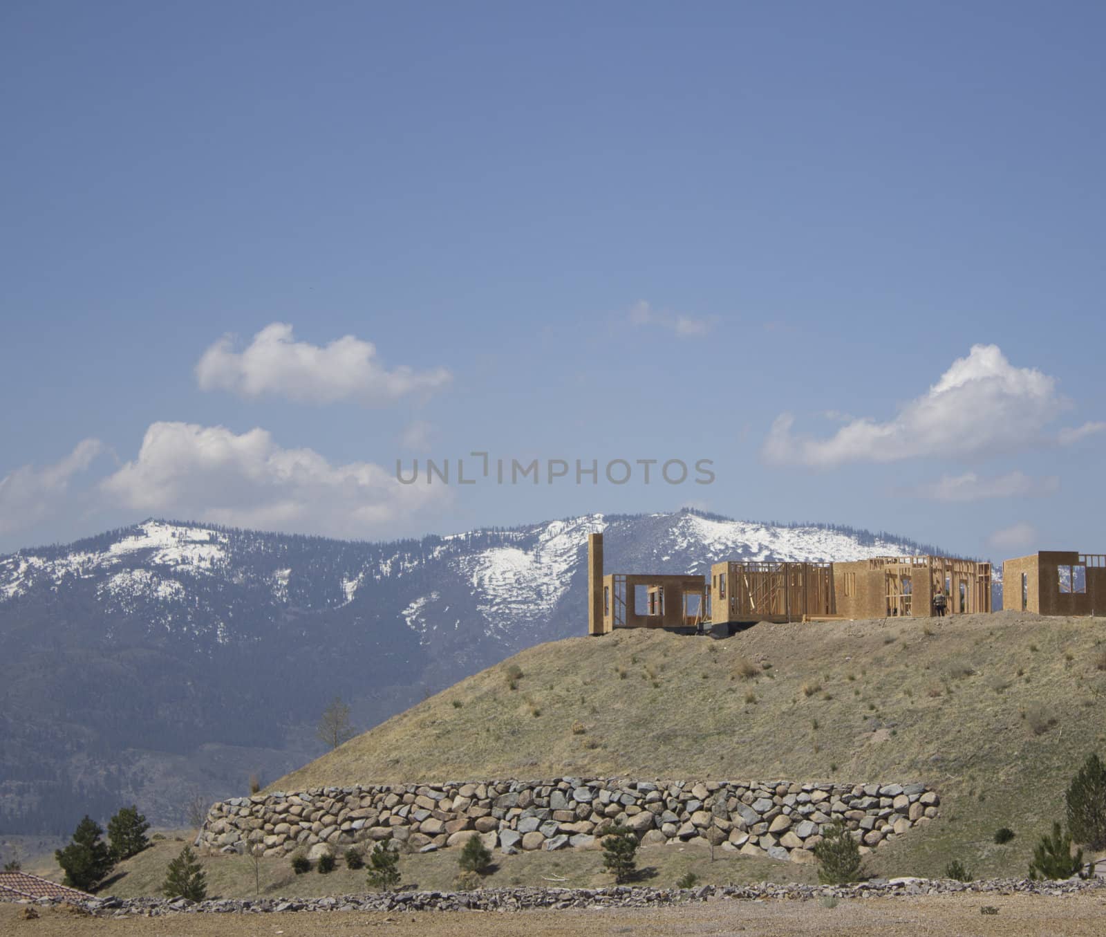 building a home on a ridge with the snowy mountains in the background