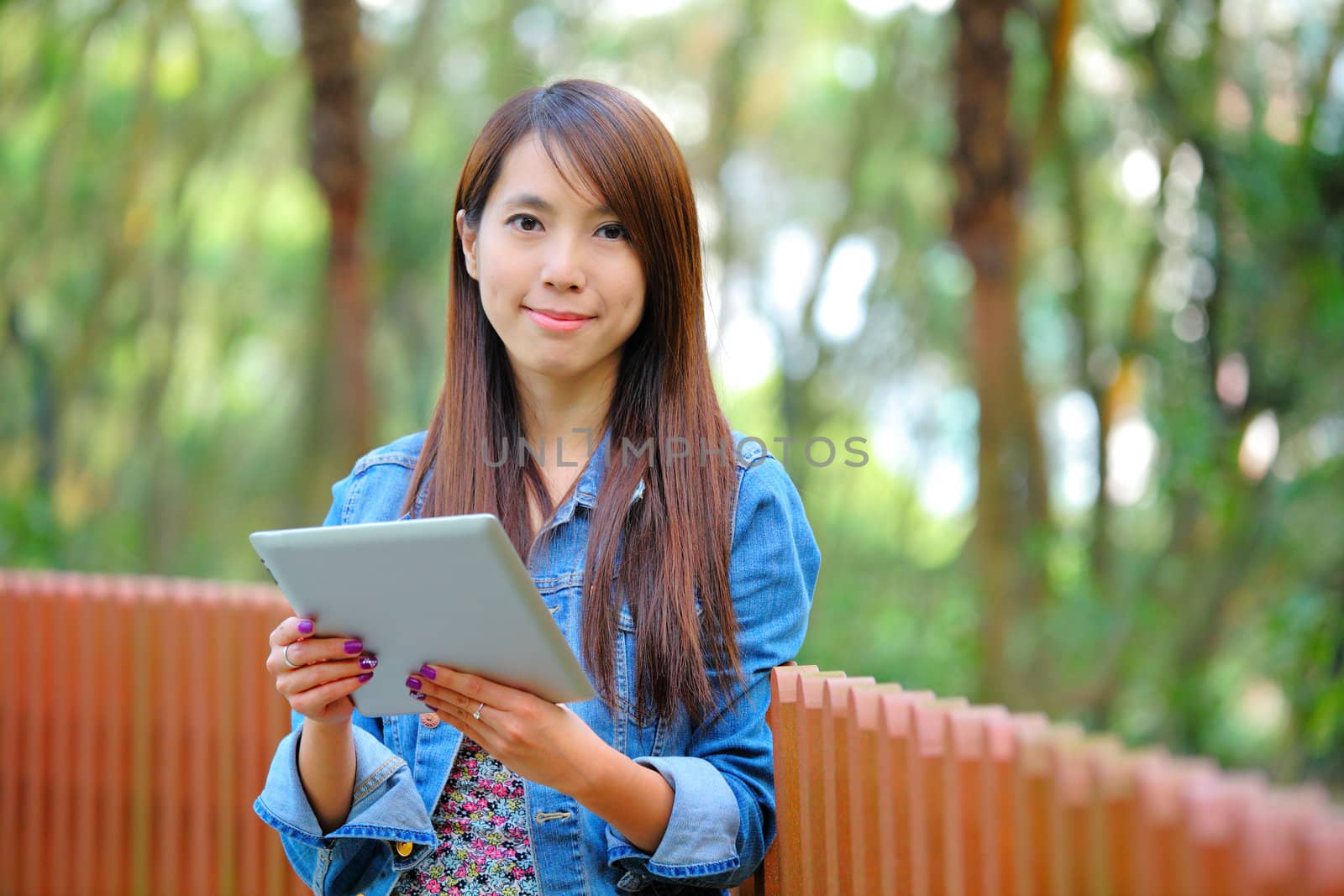 young asian woman with tablet computer outdoor by leungchopan