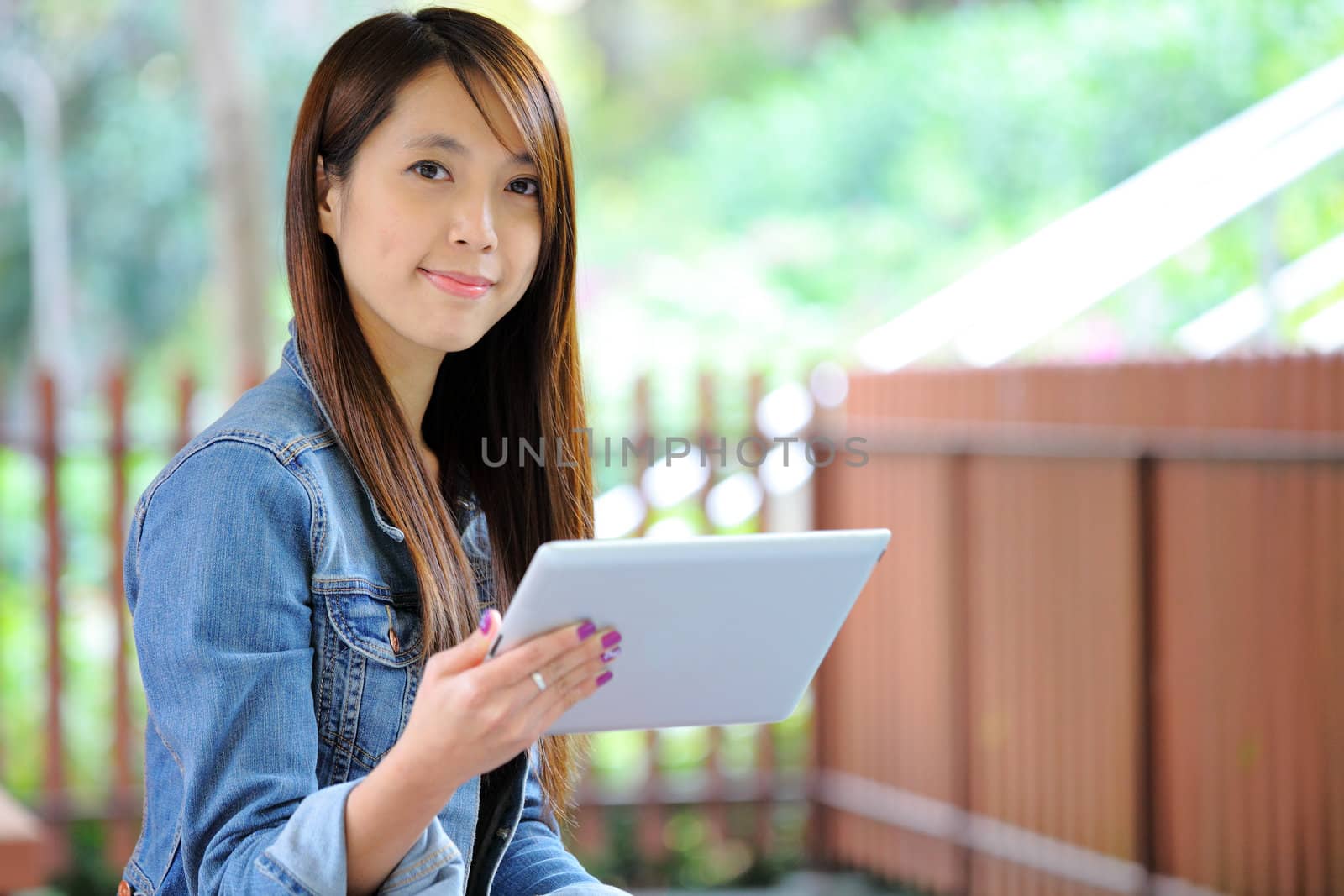 young asian woman with tablet computer outdoor by leungchopan