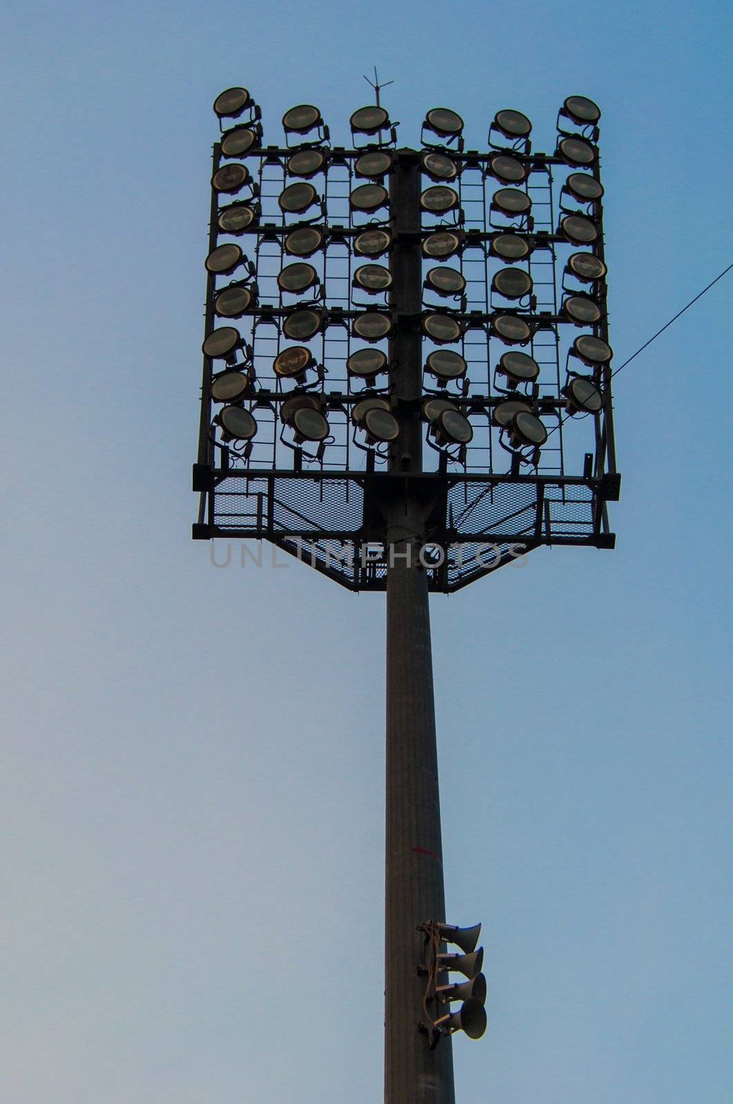high-powered stadium floodlights seen against a pretty sky