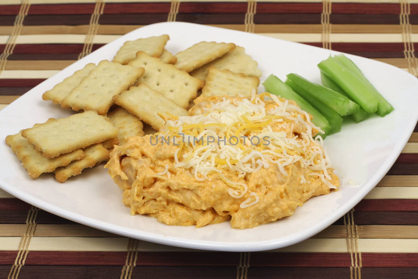 Appetizer buffalo chicken dip with crackers and celery