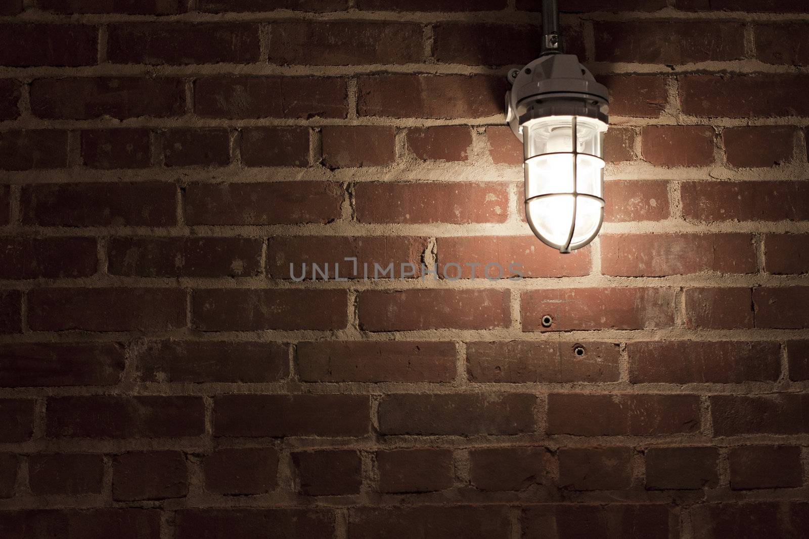 Creepy light bulb on textured red brick wall