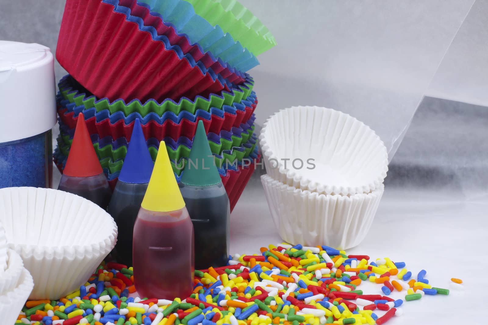 Food coloring, sprinkles and cups for decorating cupcakes