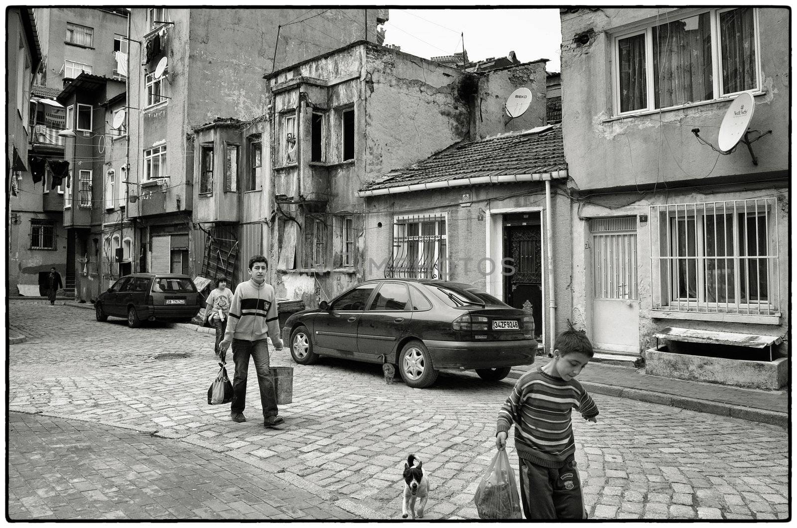 BOYS WITH GARBAGE, ISTANBUL, TURKEY, APRIL 17, 2012: Boys bringing rubbish to the container for their mother in the district of Fatih, Istanbul, Turkey.