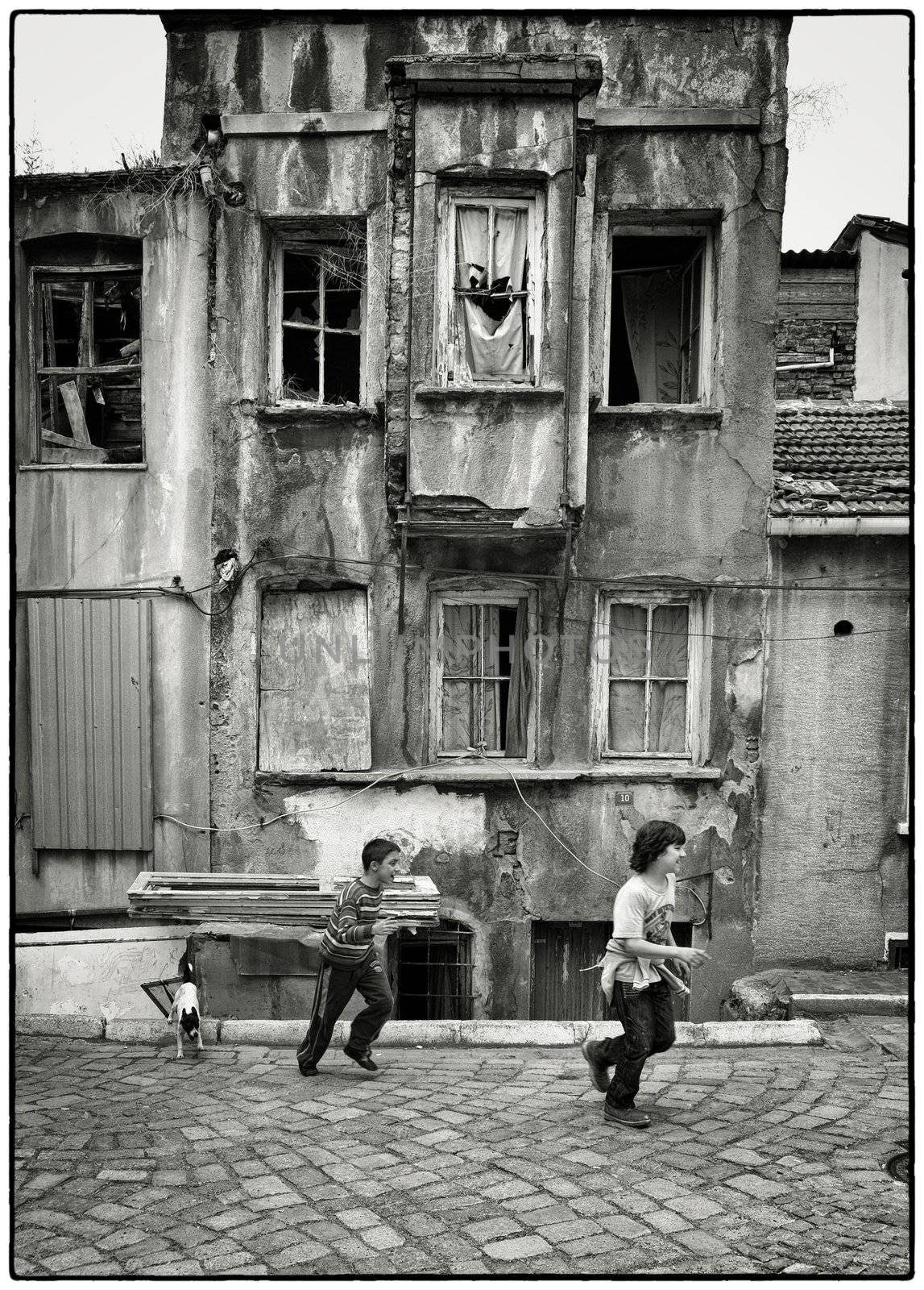 ACTIVE TYRKISH BOYS, ISTANBUL, TURKEY, APRIL 17, 2012: Kids playing around with their dog in the streets of Fatih, Istanbul, Turkey.