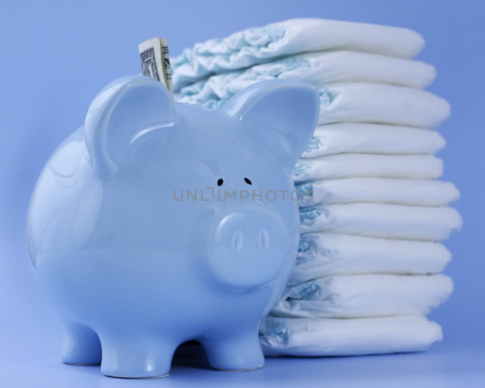 A baby blue piggy bank with a dollar bill stands in front of a tall pile of diapers against a baby blue background