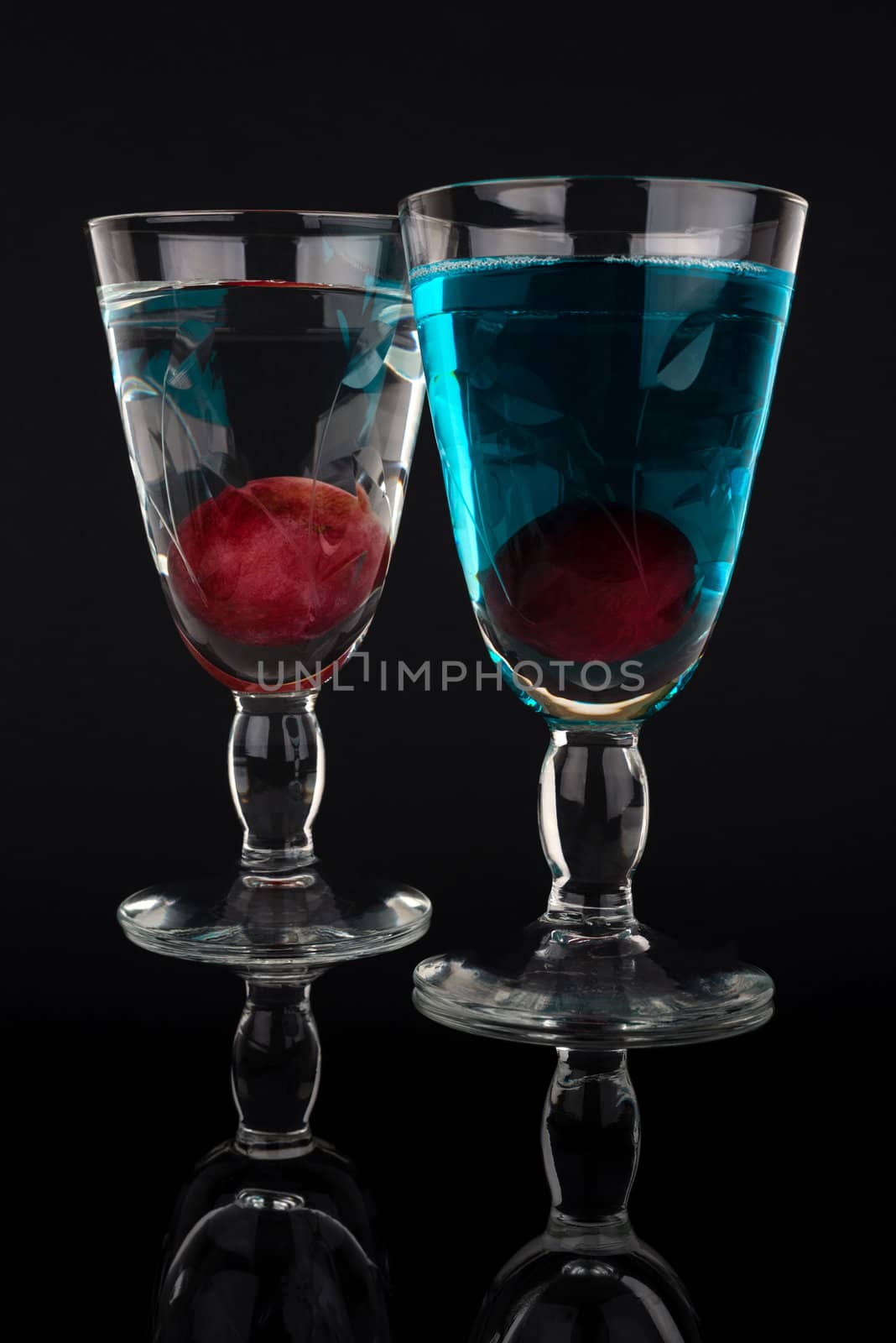 Two cocktails isolated on black background.