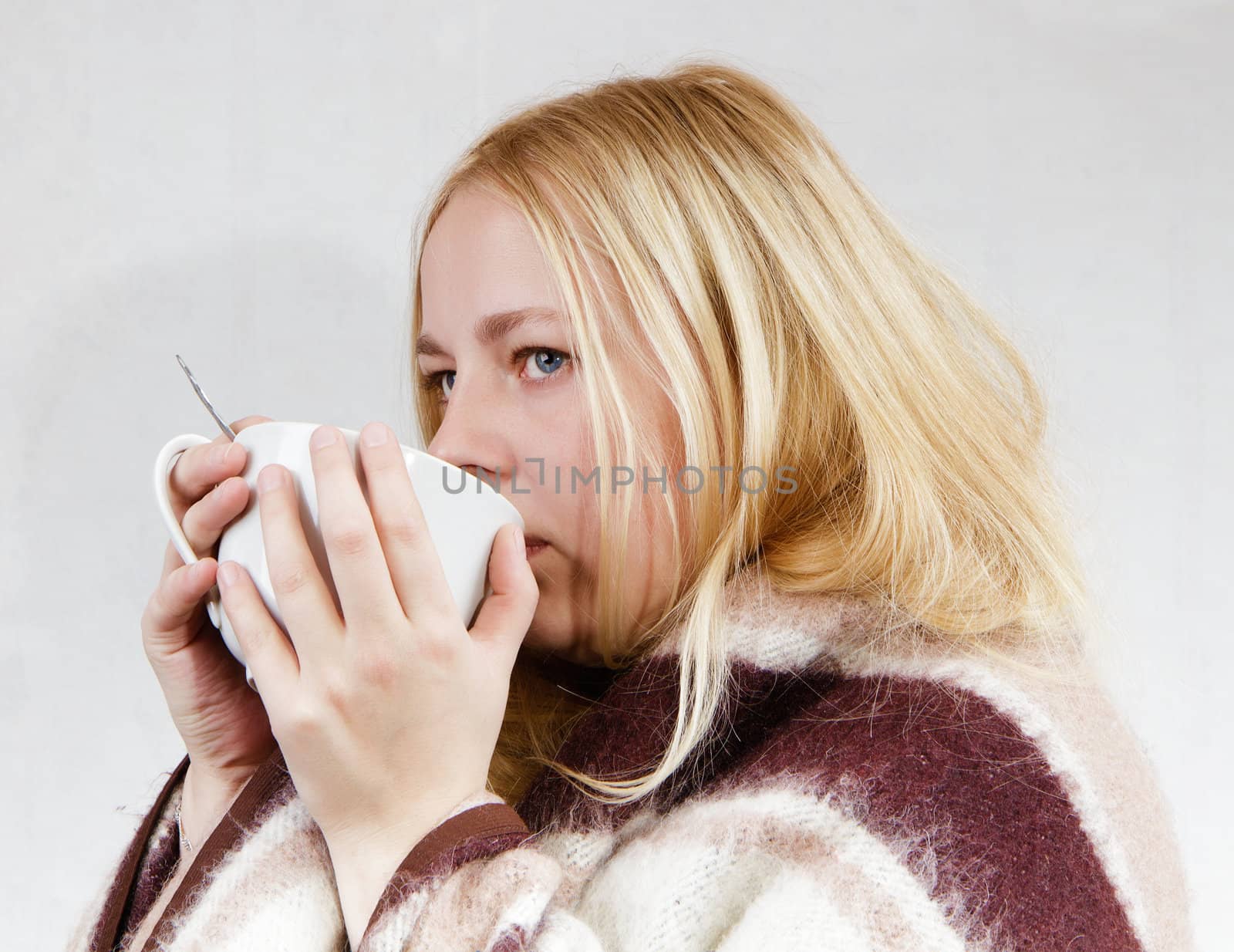 girl with a cup wrapped in a blanket. white background