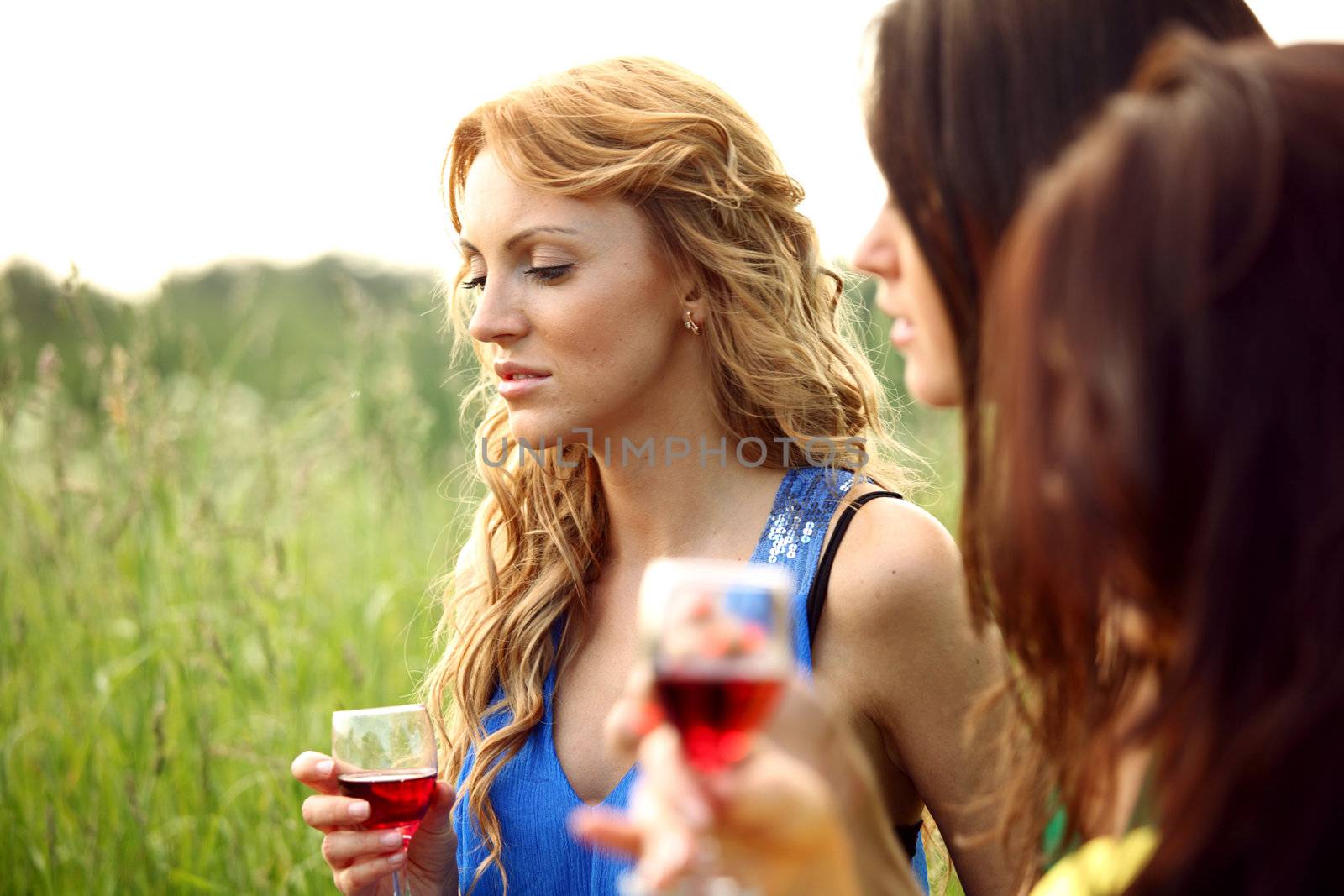 girls drink wine on nature background