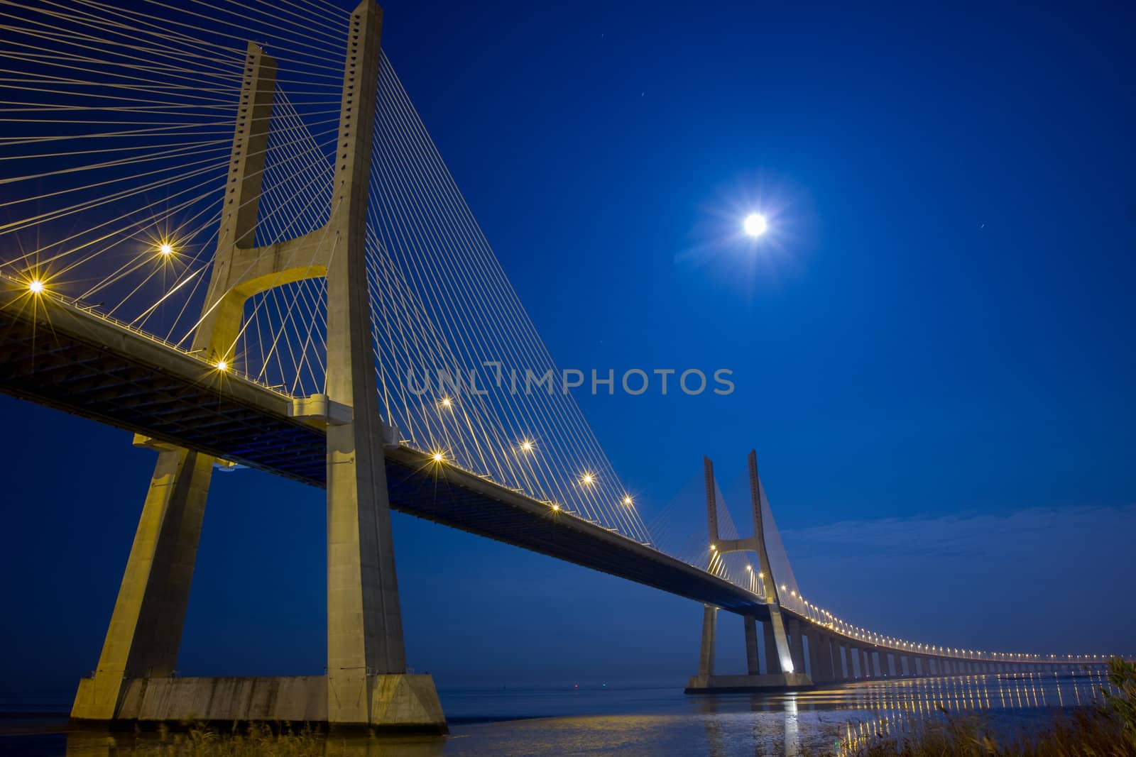 Long Vasco da Gama bridge at night under moonlight