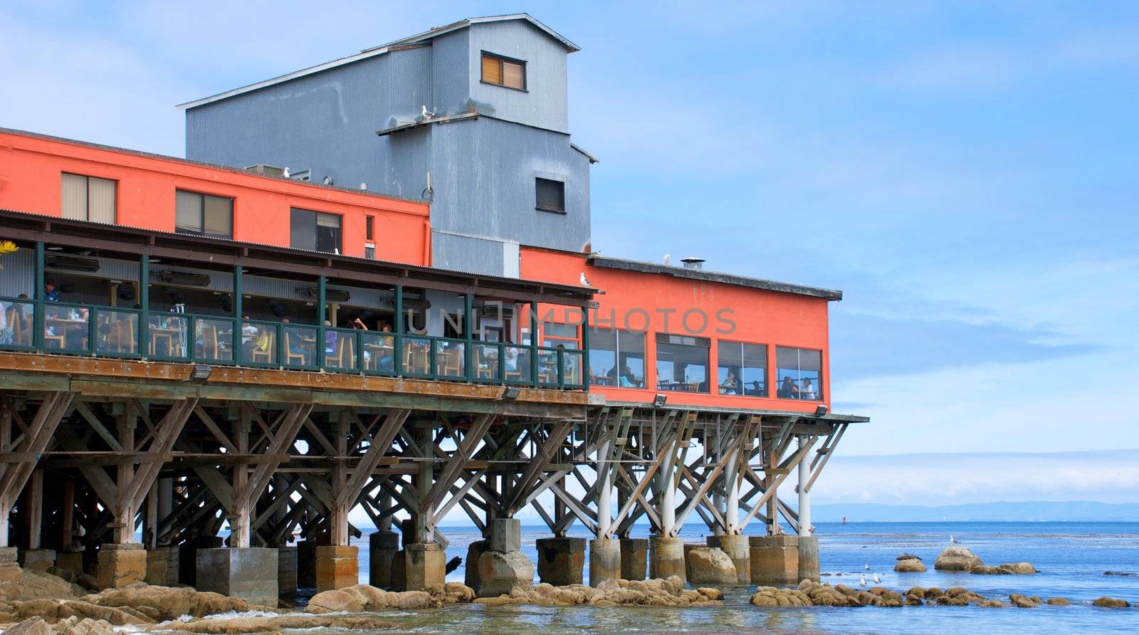 A restaurant sitting on a large wooden pier along the coast in Monterey California