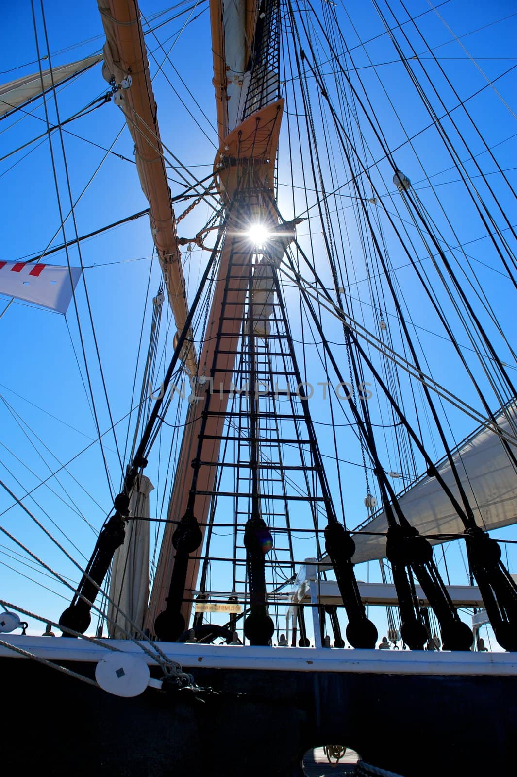 The sun peeks through the ropes and rigging of an old sailing ship