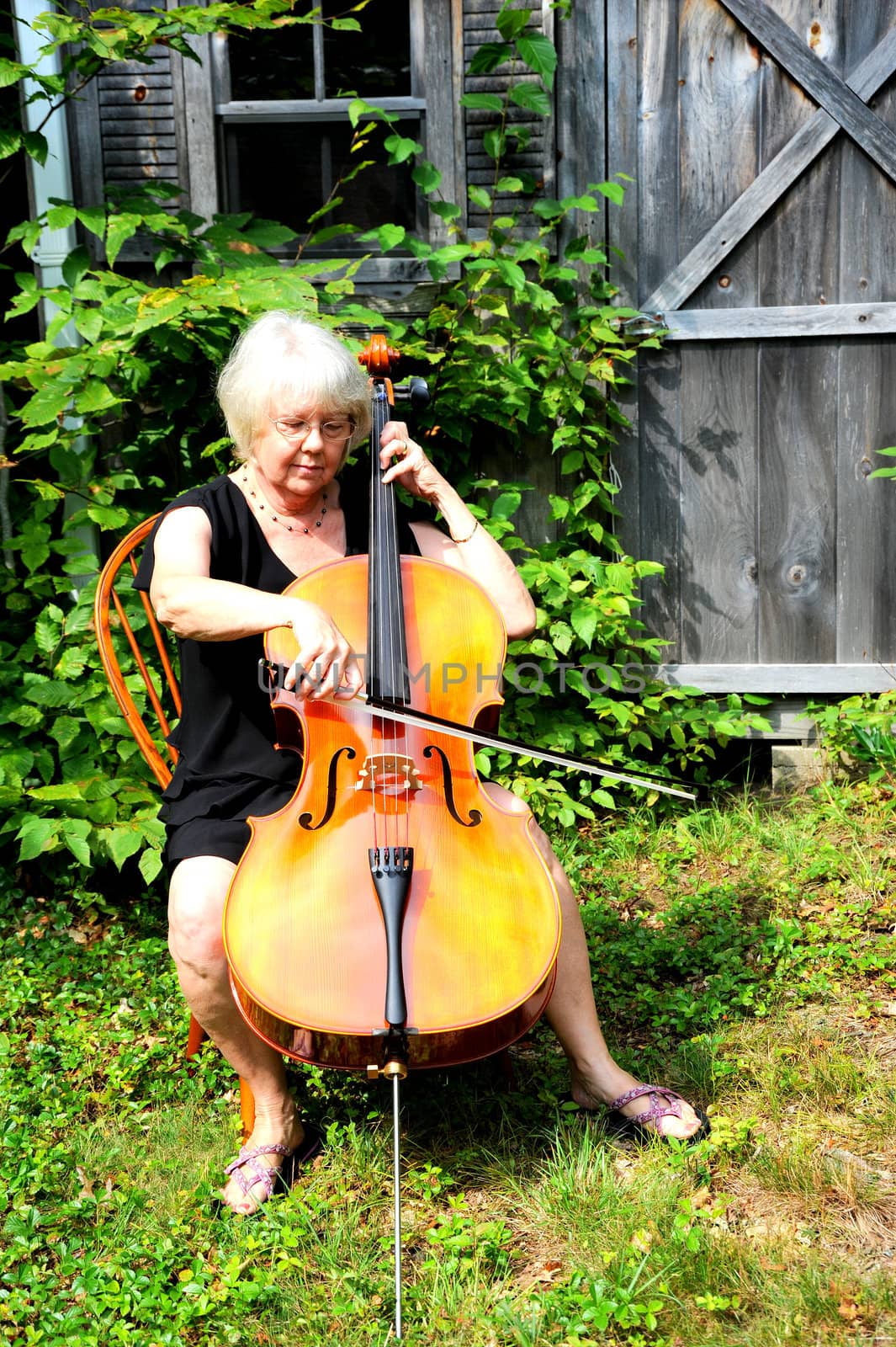 Female cellist with her cello outside.