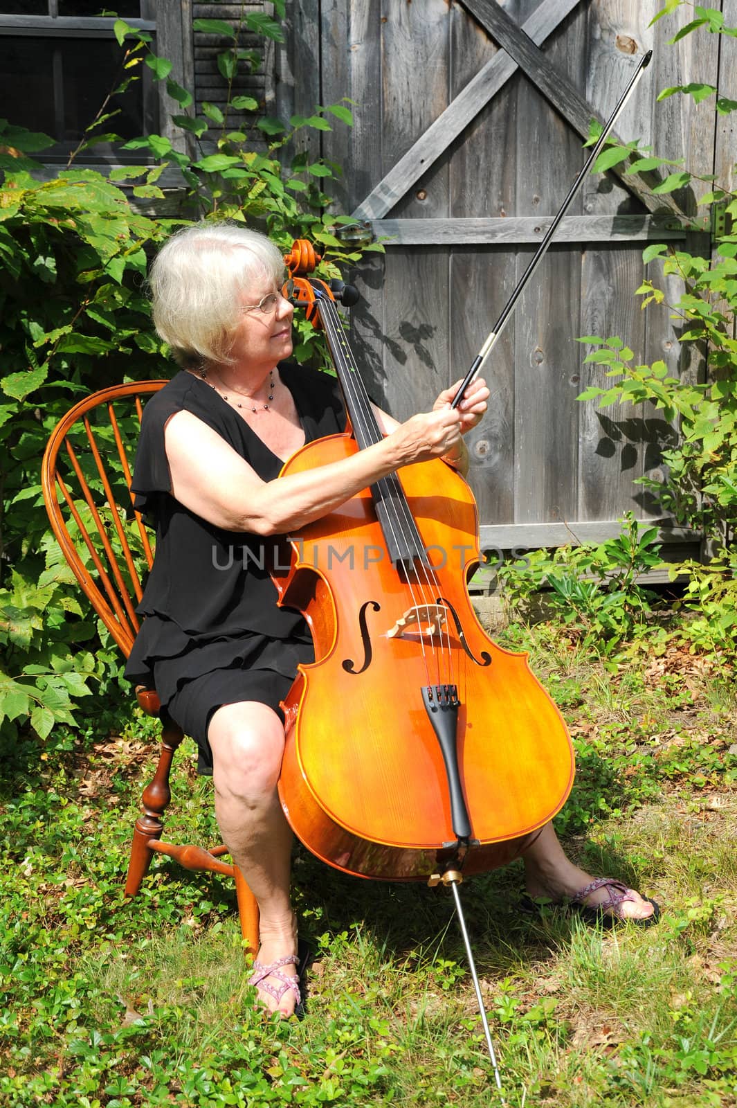 Female cellist with her cello outside.